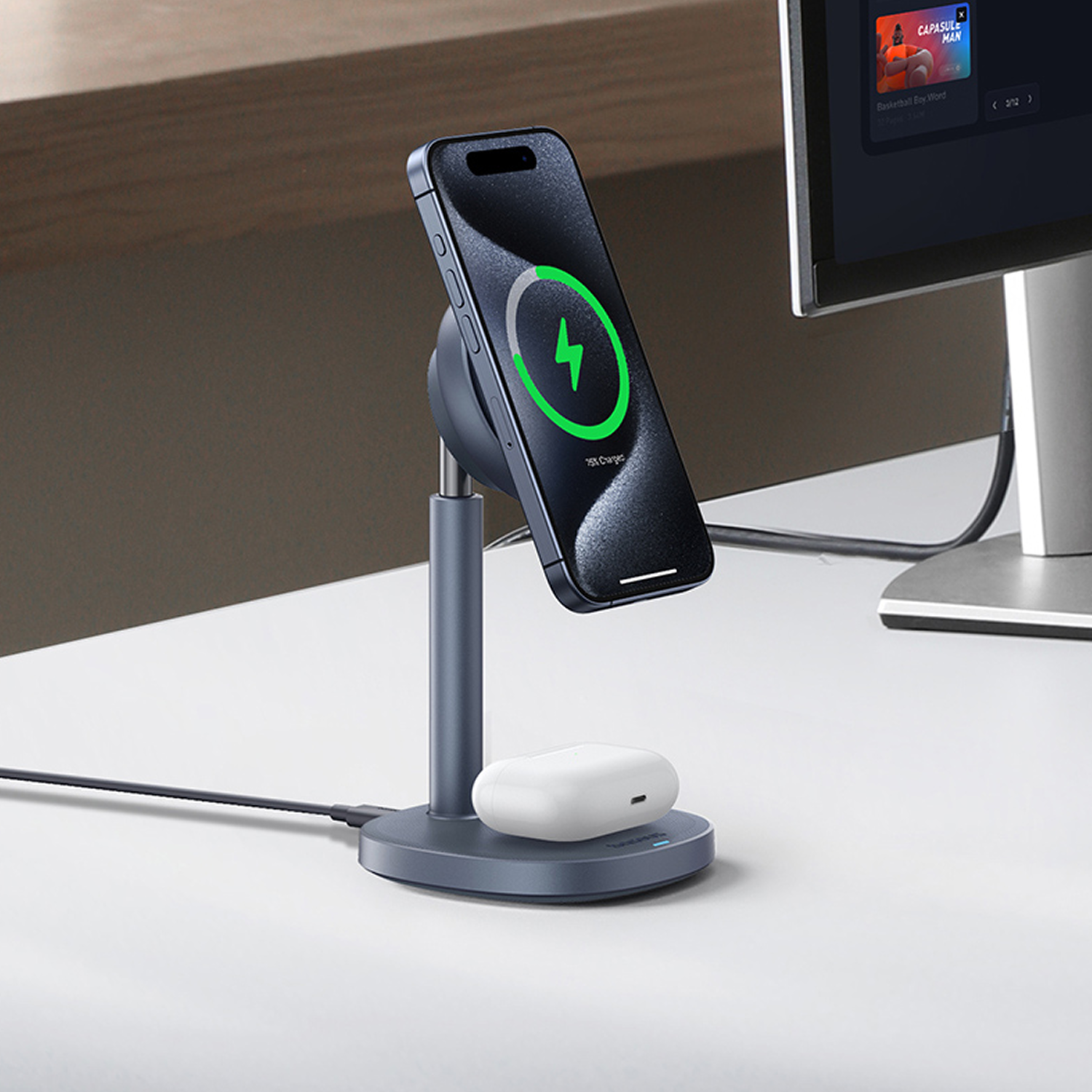 Un smartphone se carga en un soporte, con auriculares en una base de carga cerca.