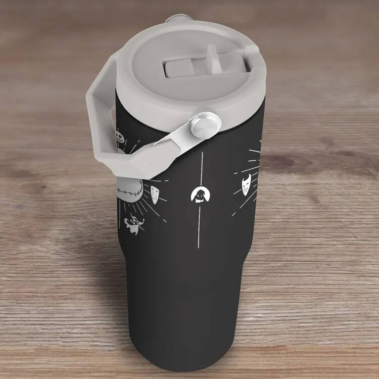 Vaso negro con asa y tapa blancas, decorado con símbolos espeluznantes.