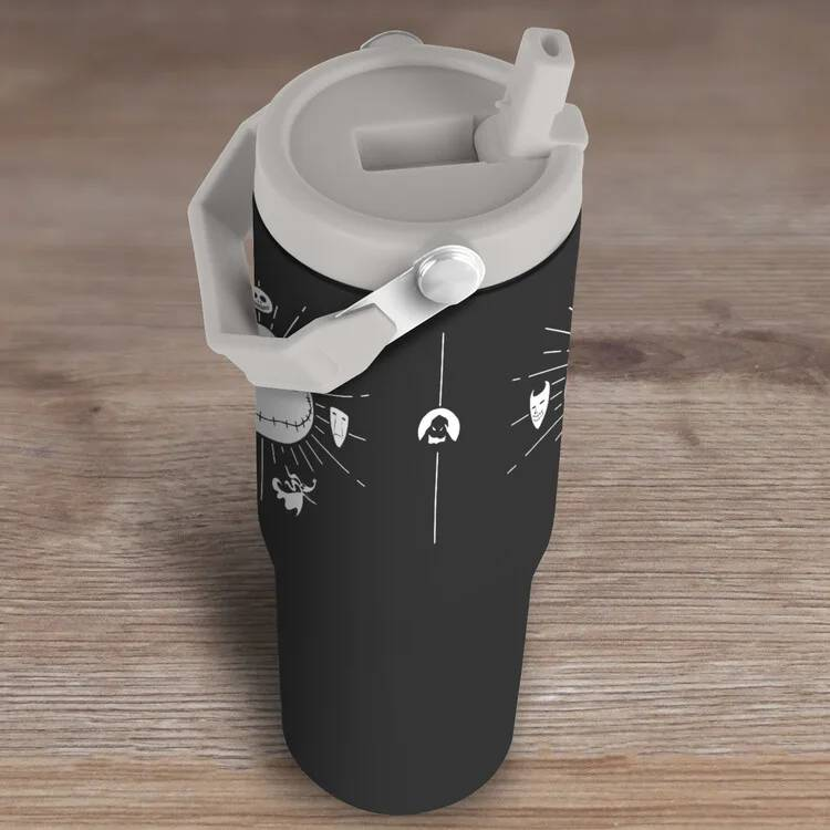 Vaso negro con estampado blanco de máscaras y fantasmas, tapa y pajita grises.