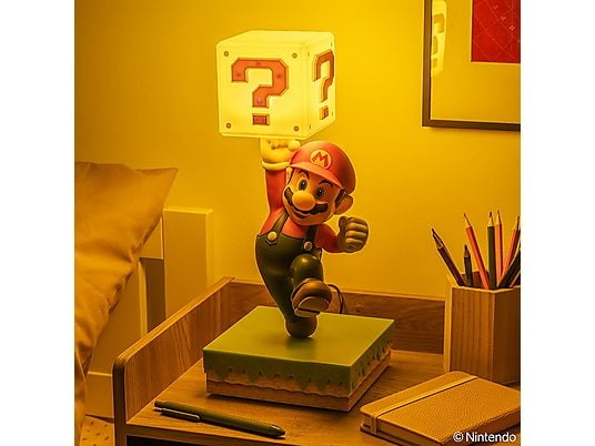 Figura de Mario sostiene un bloque de signo de interrogación brillante sobre un escritorio.