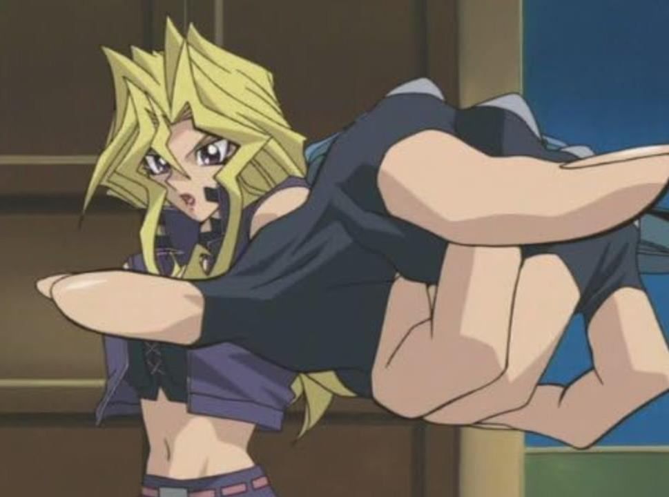 Eine Anime-Figur mit blondem Haar und lila Augen, die einen dunklen BH und eine lila Jacke trägt.