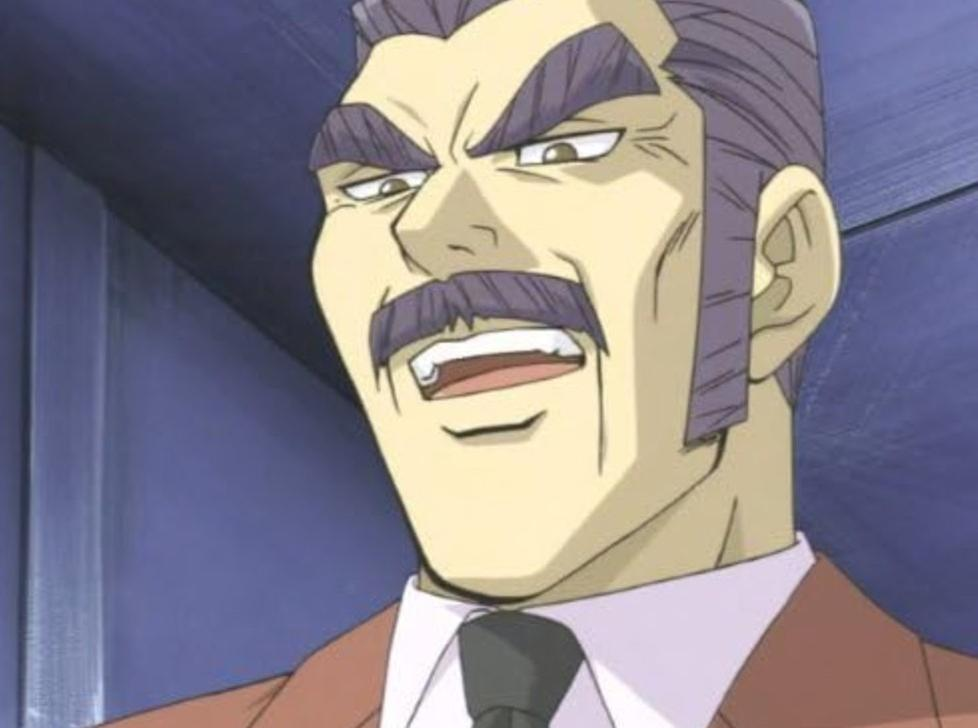 Anime-Mann mit lila Haaren, Schnurrbart und Anzug spricht vor blauem Hintergrund.
