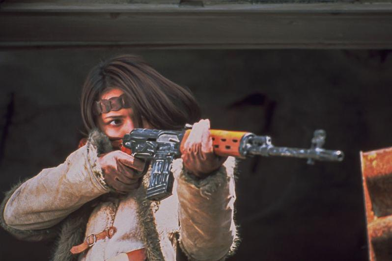 Eine Frau mit einem Gewehr zielt.