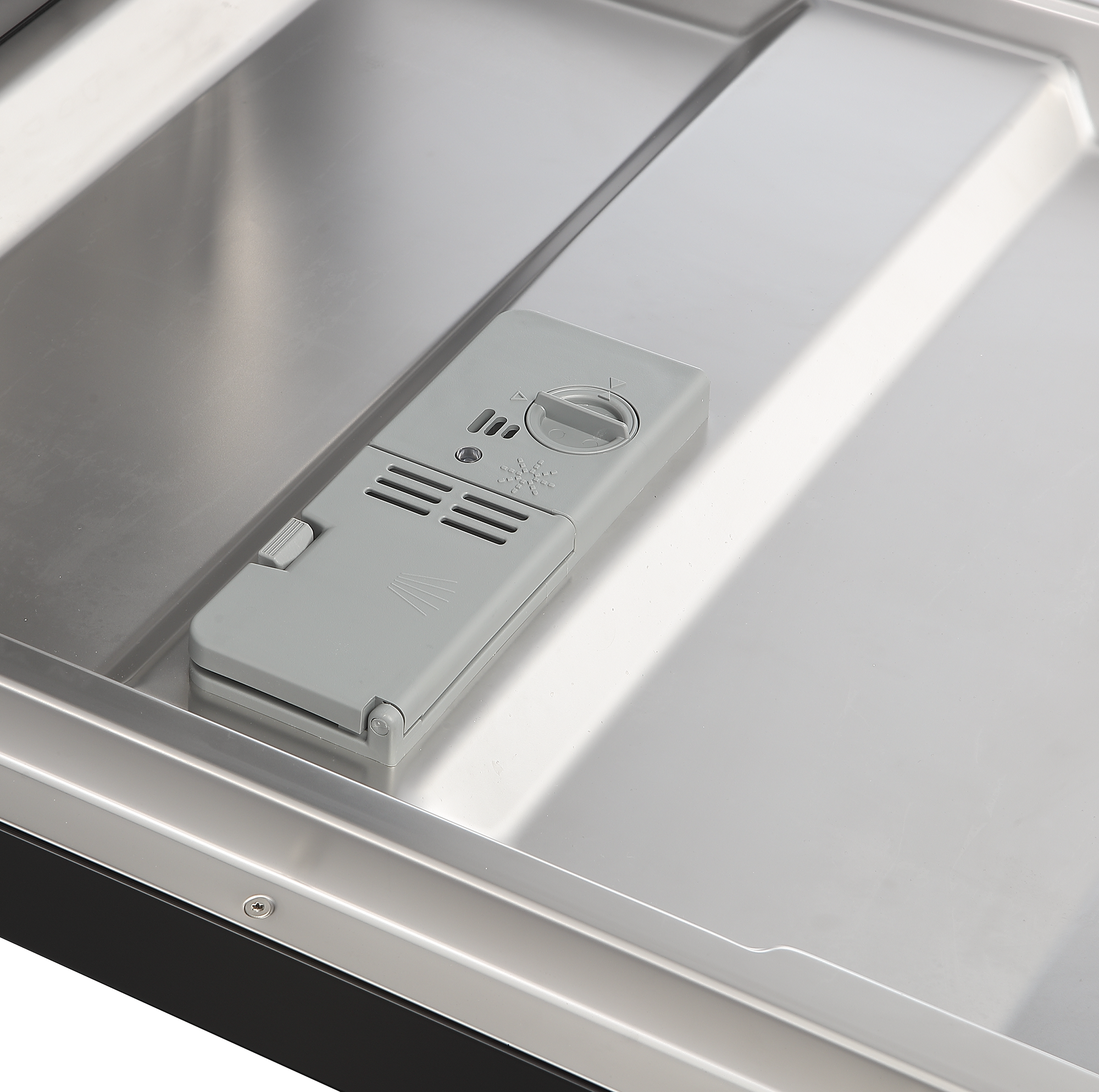 Ein grauer Spülmittelbehälter mit Drehknopf in einem Edelstahldishwasher.