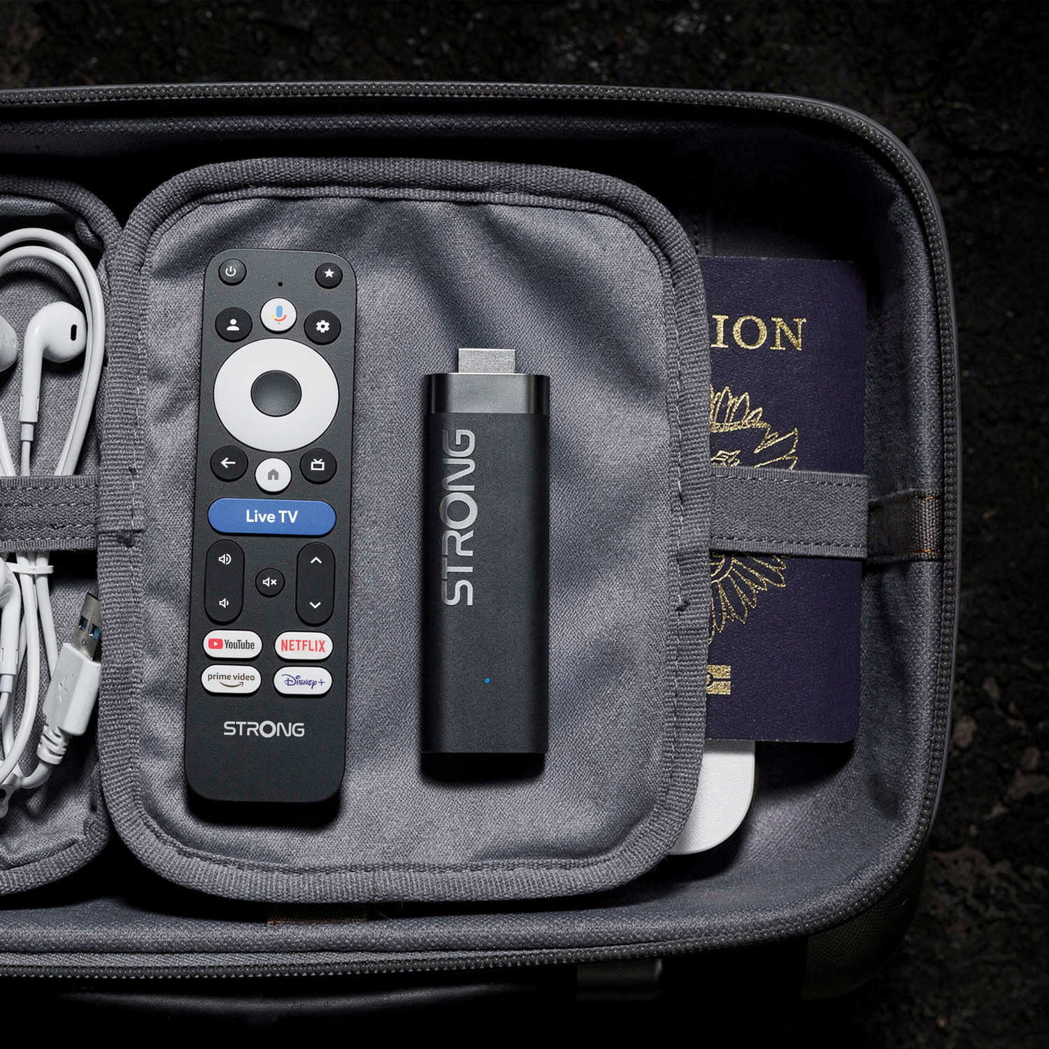 Un estuche de viaje con mando, stick de streaming, auriculares y pasaporte.