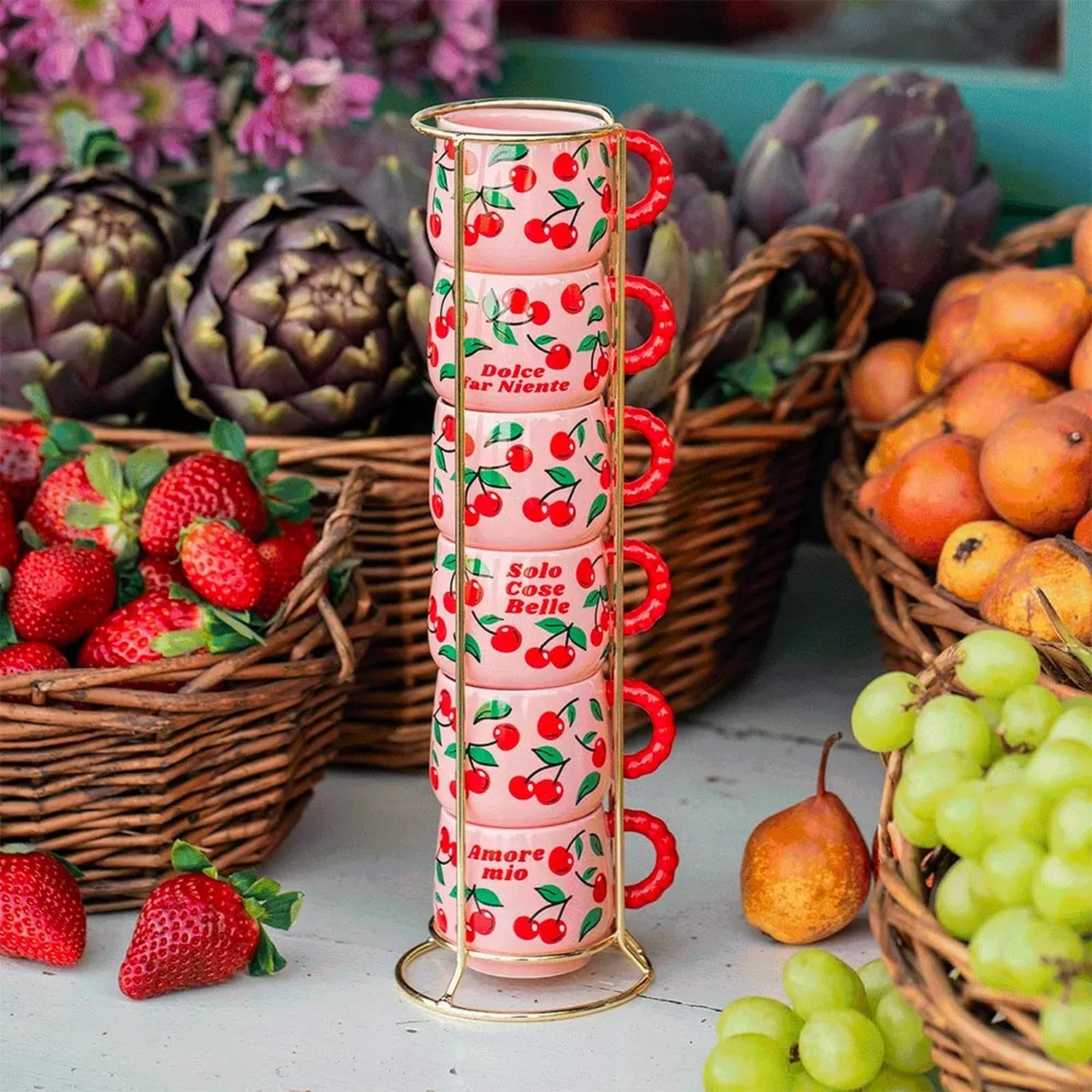 Tazze rosa con ciliegie e testo su un supporto, circondate da frutta e verdura.