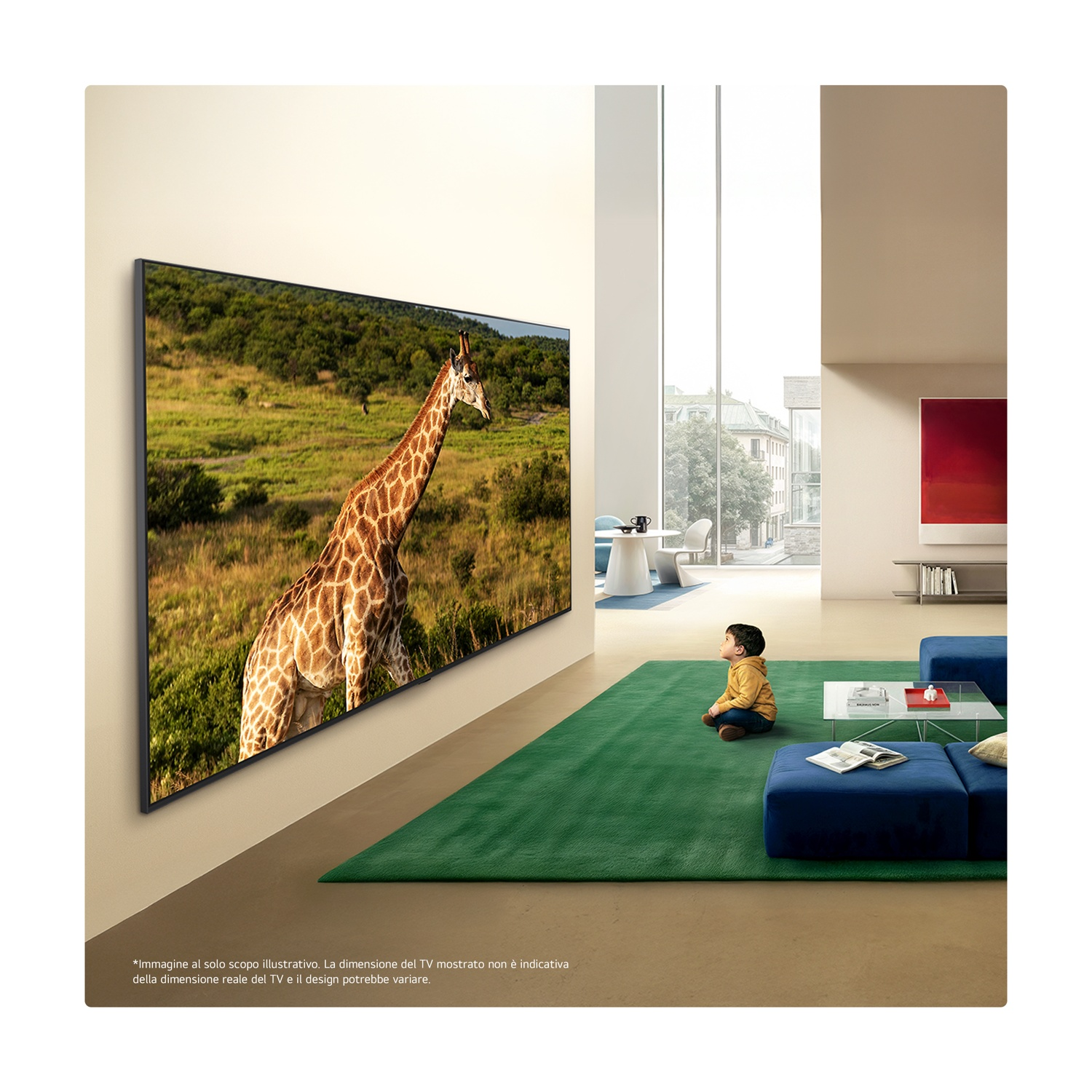 Un bambino siede su un tappeto verde, guardando una TV con una giraffa nella savana.
