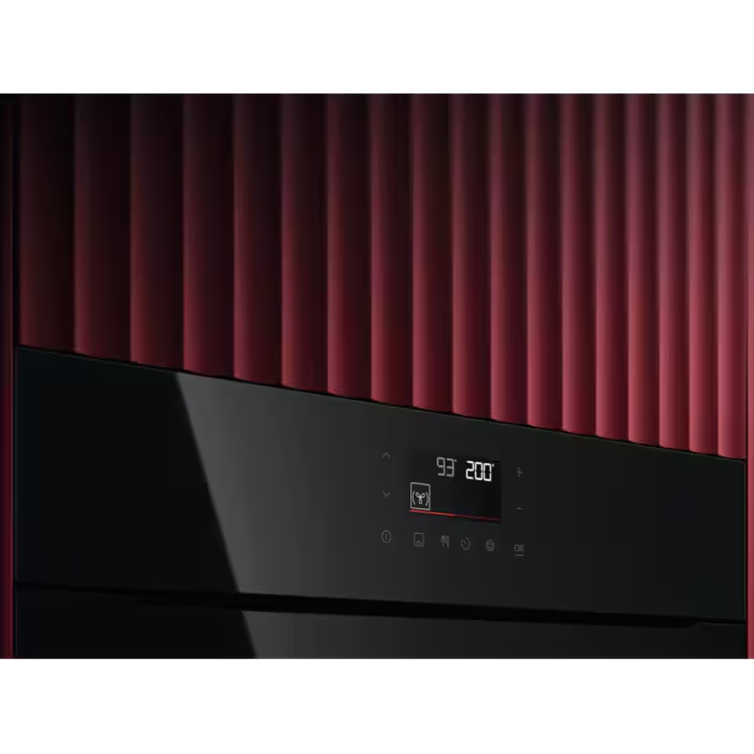 Un four moderne avec panneau de contrôle noir sur fond rouge nervuré verticalement.
