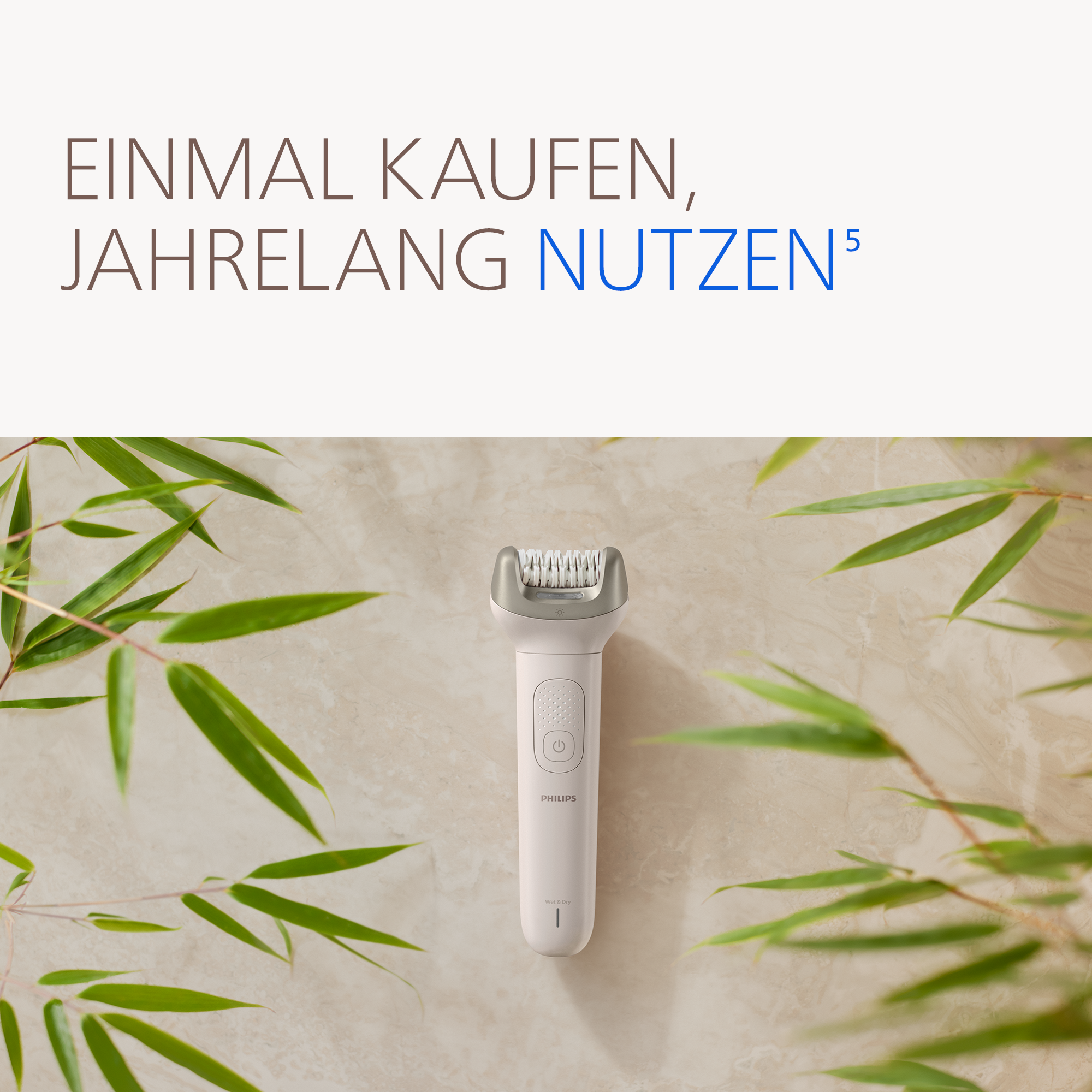 Ein hellrosa Philips Epilierer mit Rasierkopf auf Marmor, umgeben von Bambusblättern.