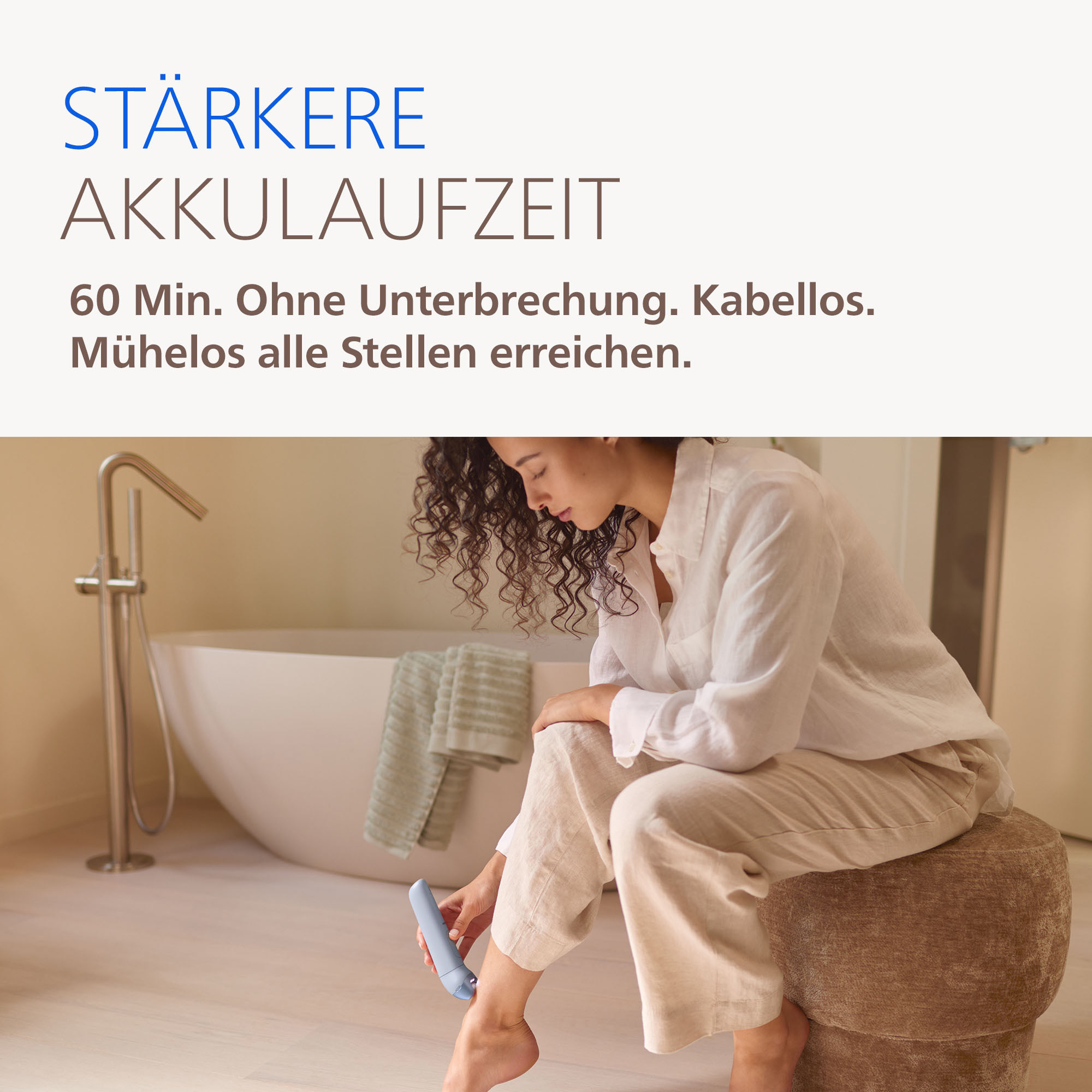 Frau epiliert Bein im Bad mit kabellosem Gerät. Längere Akkulaufzeit.