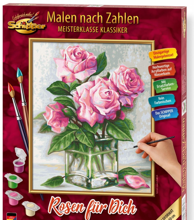 Ein Malset mit rosa Rosen in einer Glasvase, Pinsel und Farben.