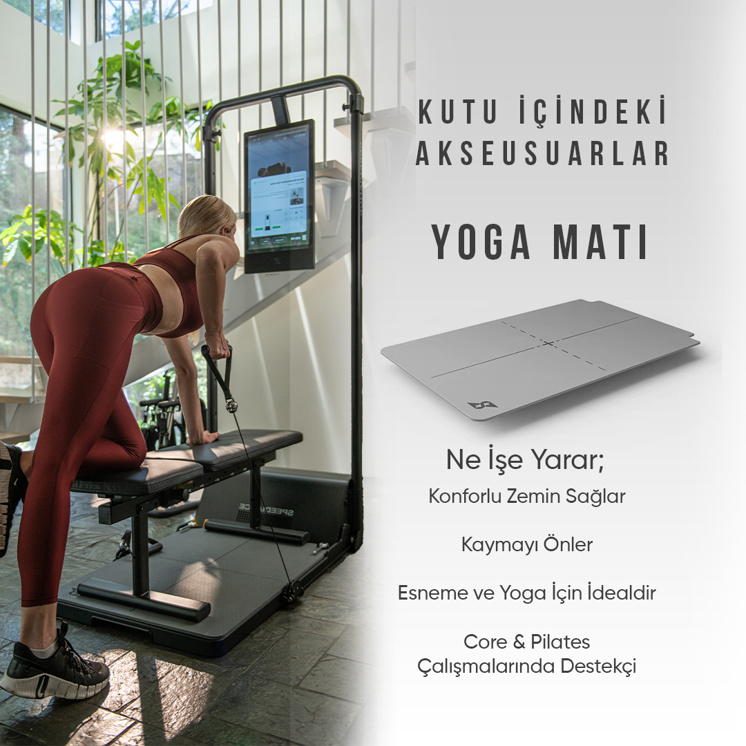 Kadın bir yoga matı ekranının yanında bir alette egzersiz yapıyor.