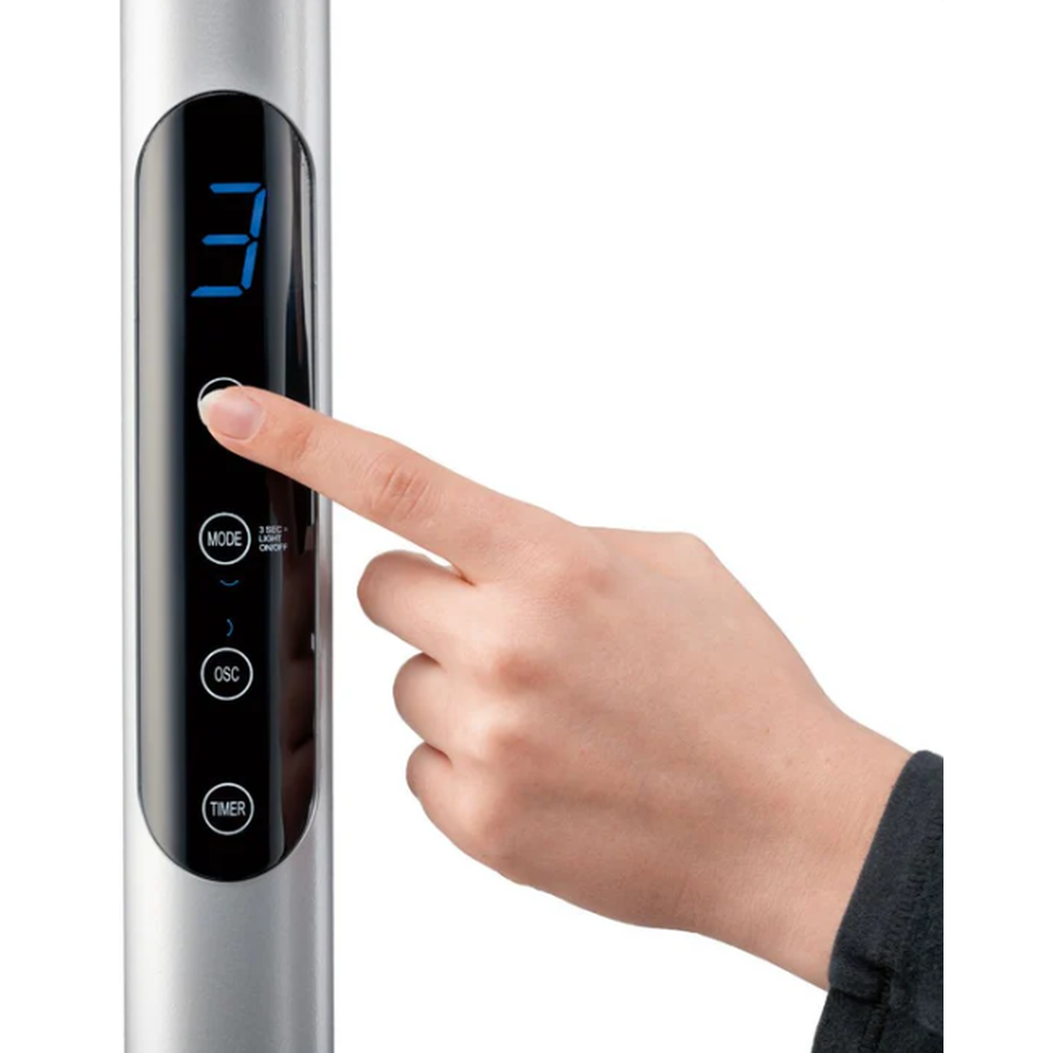 A hand presses a button on a silver device with a digital display.