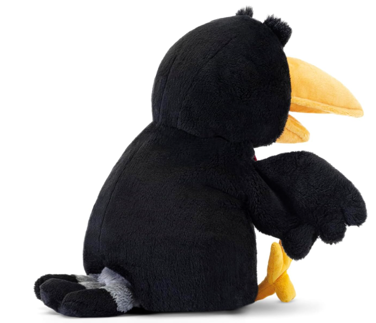 Ein schwarzes Stofftier mit gelbem Schnabel sitzt und hält etwas Gelbes.