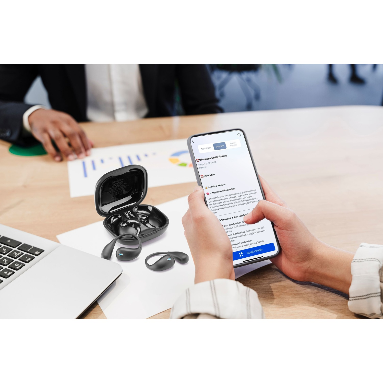 Uno smartphone mostra un riepilogo della riunione. Un paio di auricolari wireless è lì vicino.