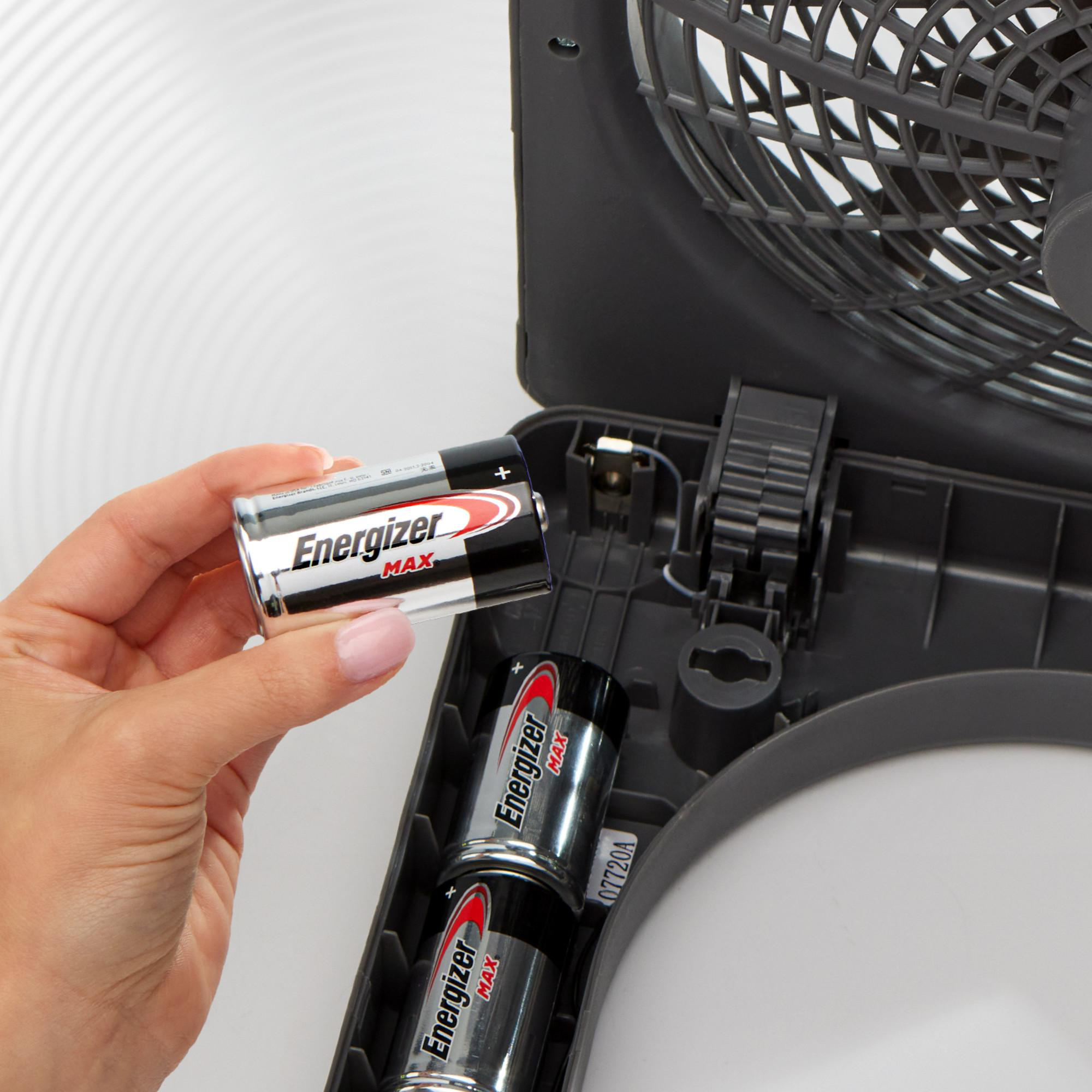 Eine Hand setzt eine Energizer Max AA-Batterie in ein Batteriefach ein.