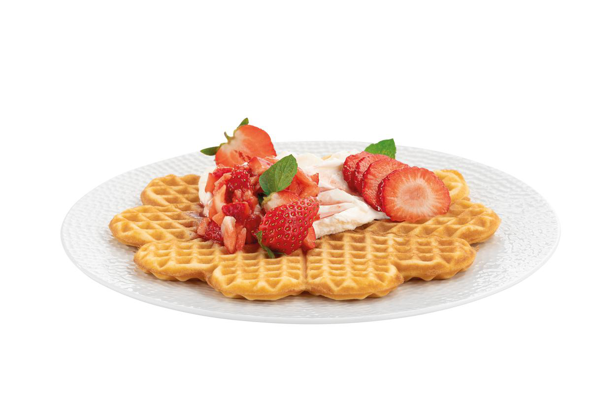 Ein Herz-Waffel mit Sahne, Erdbeeren und Minze auf einem Teller.