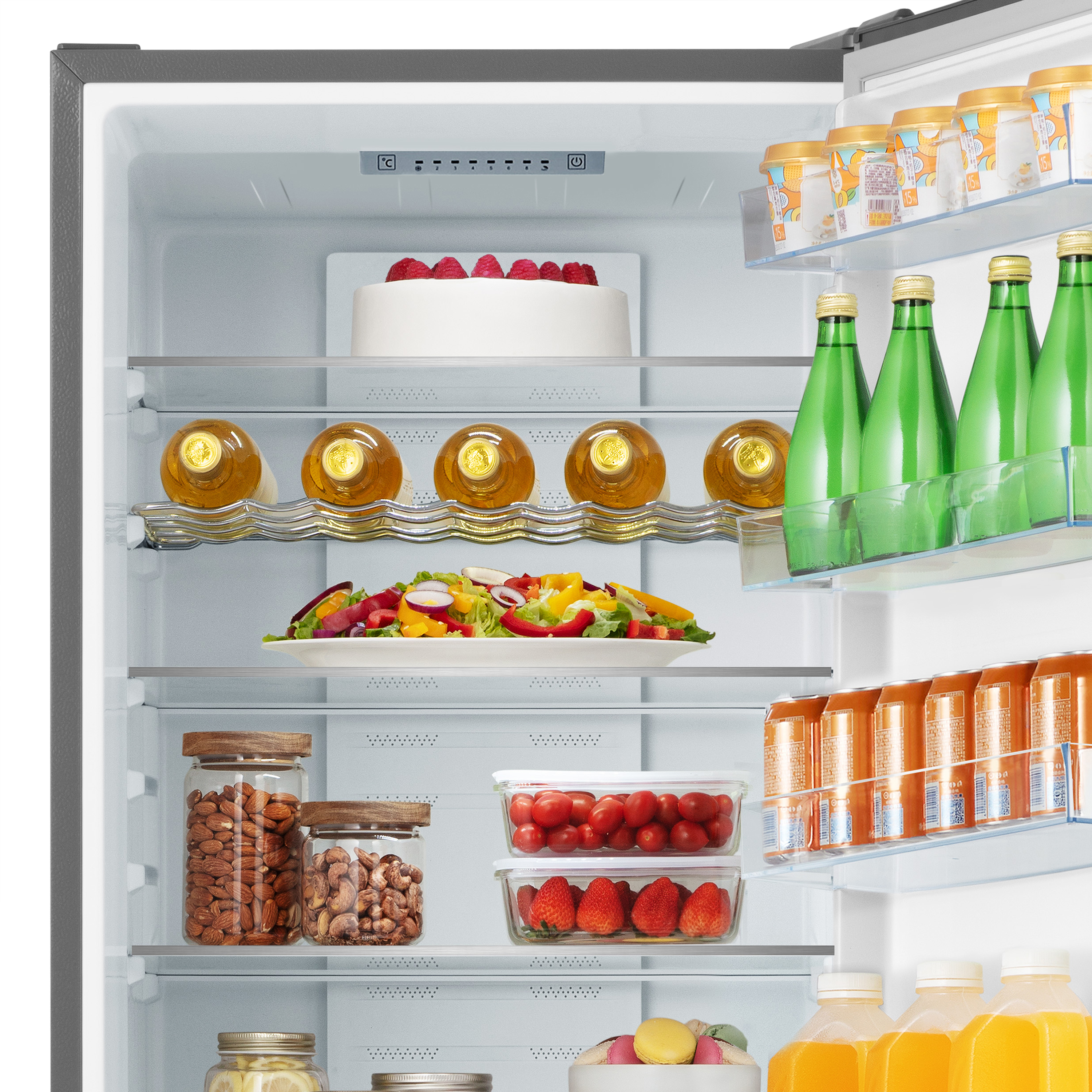 Refrigerador abierto lleno de comida: pastel, ensalada, botellas, latas y frascos.