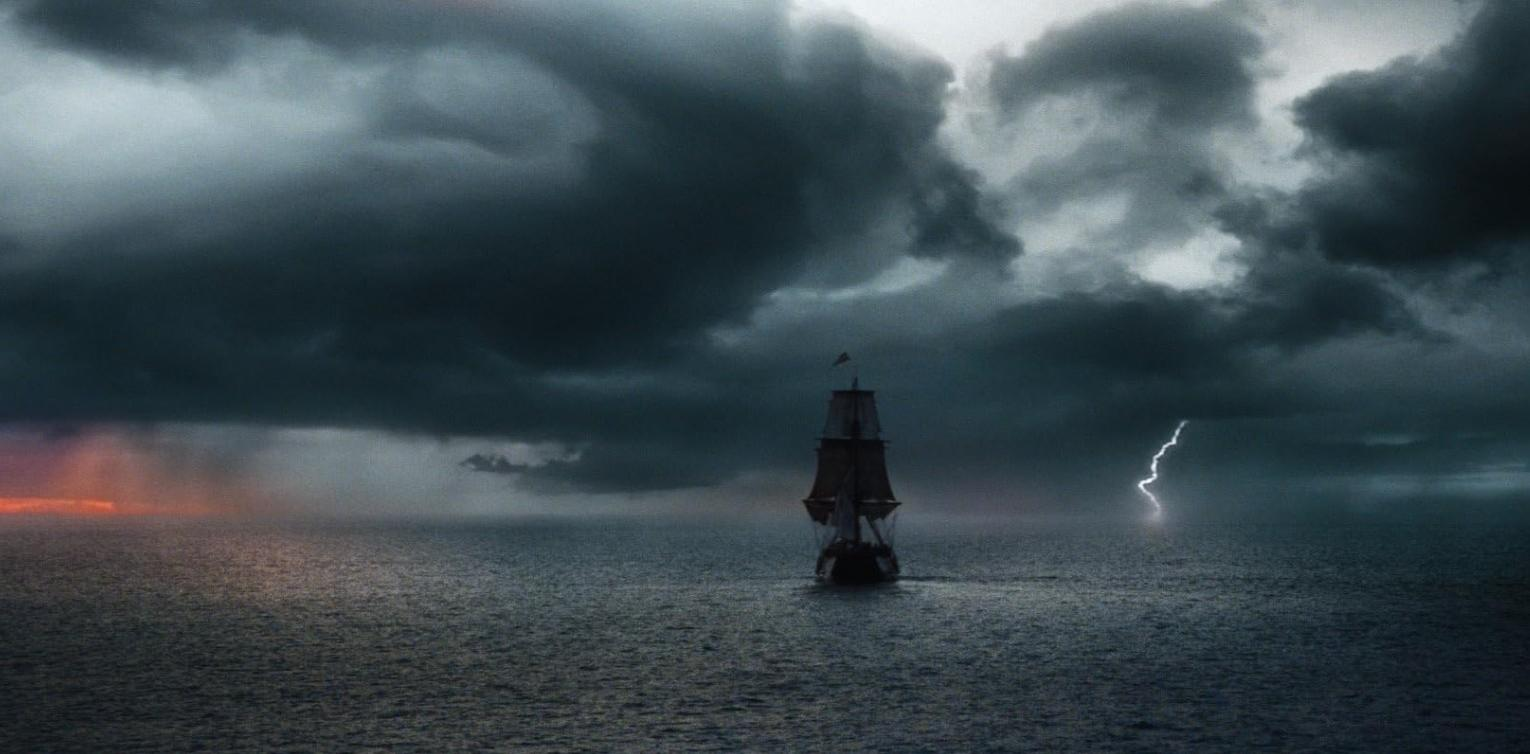 Ein Segelschiff segelt auf stürmischer See unter dramatischen Wolken mit Blitz.