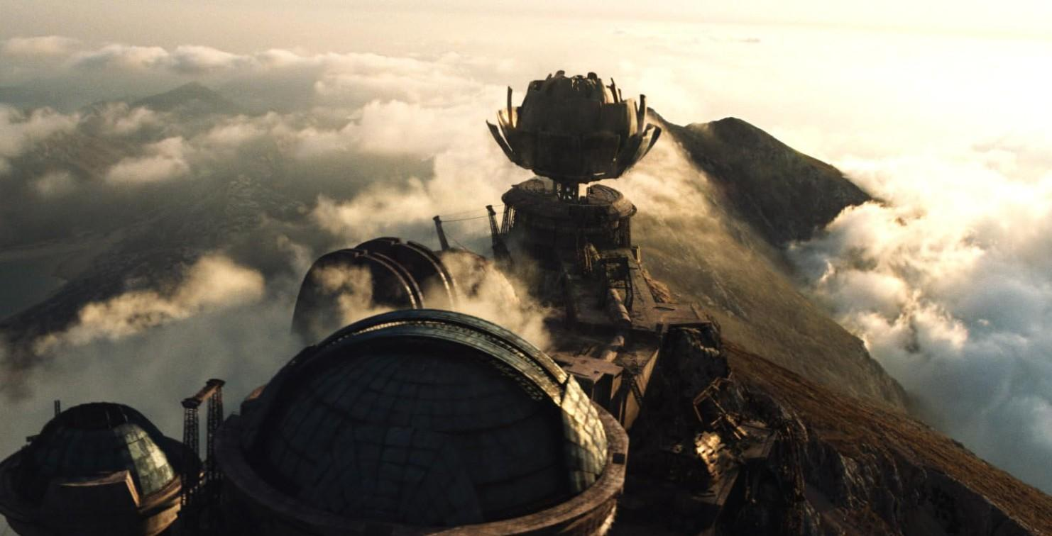 Futuristische Gebäude auf einem Berg, umgeben von Wolken.
