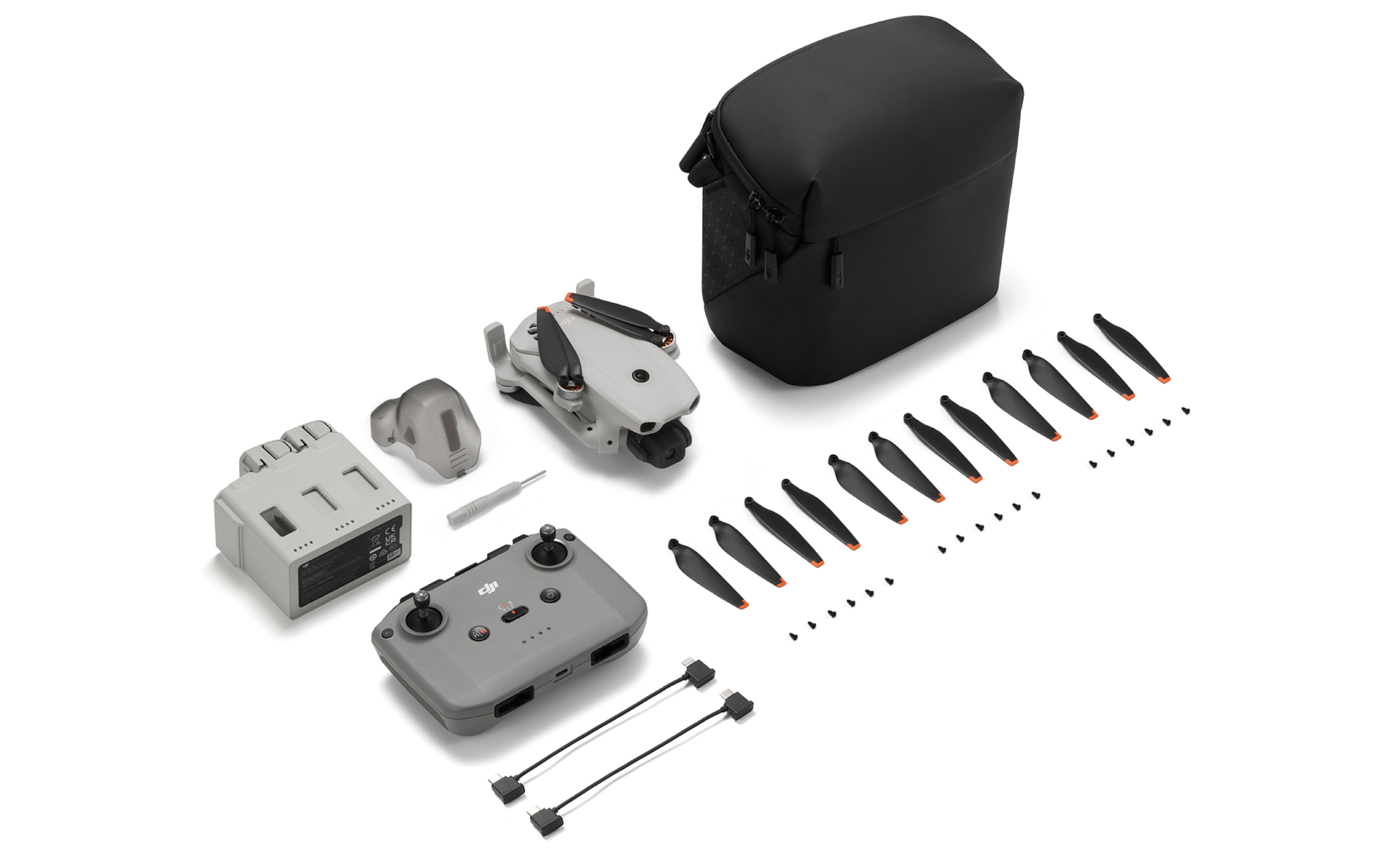 Yedek parçalar, uzaktan kumanda ve taşıma çantası içeren gri mini drone kiti.