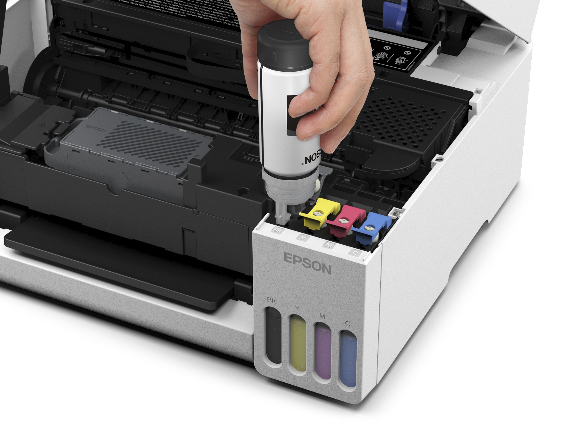 Bir el beyaz bir Epson yazıcıya mürekkep dolduruyor.