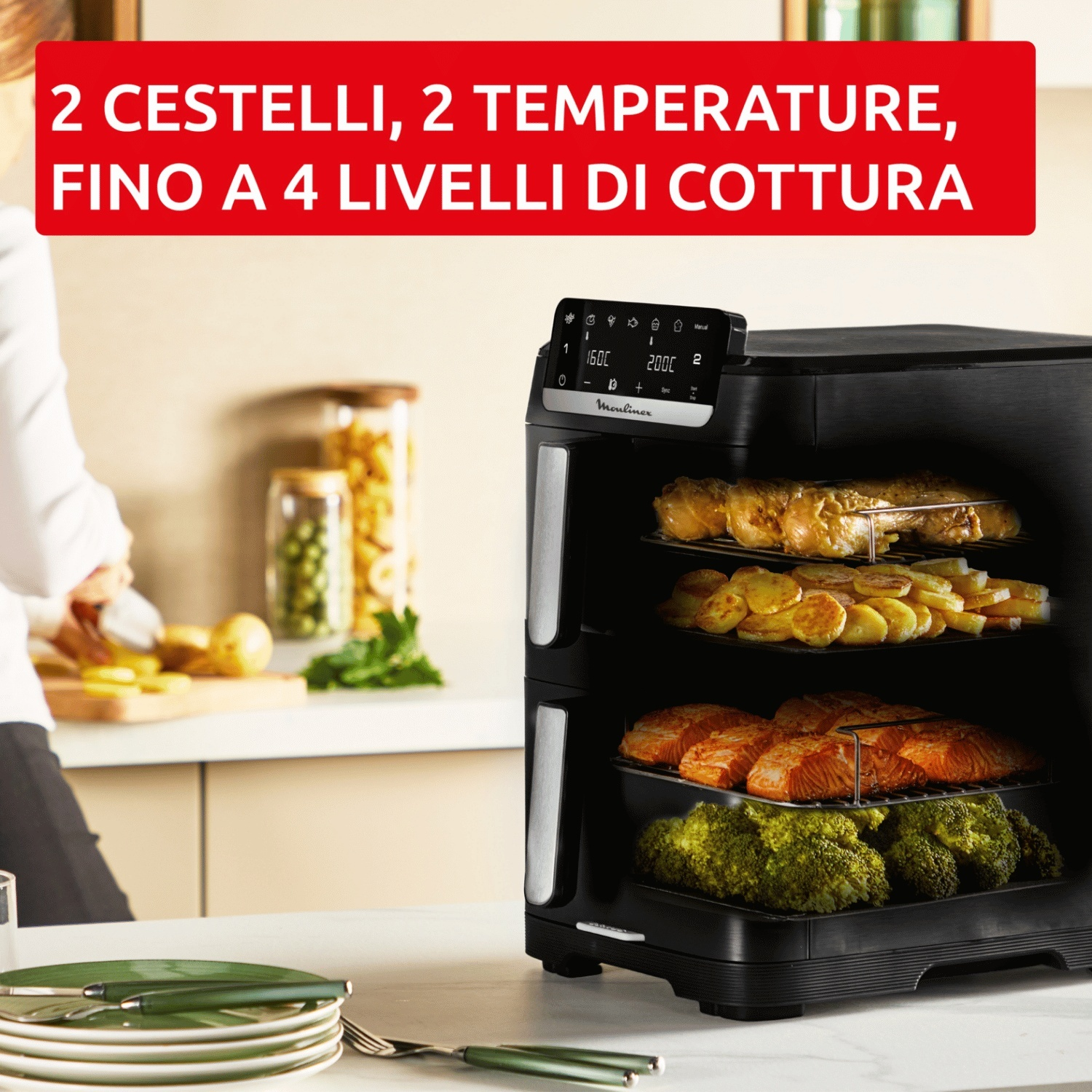 Una multicooker nera a tre ripiani con pollo, patate, salmone e broccoli.
