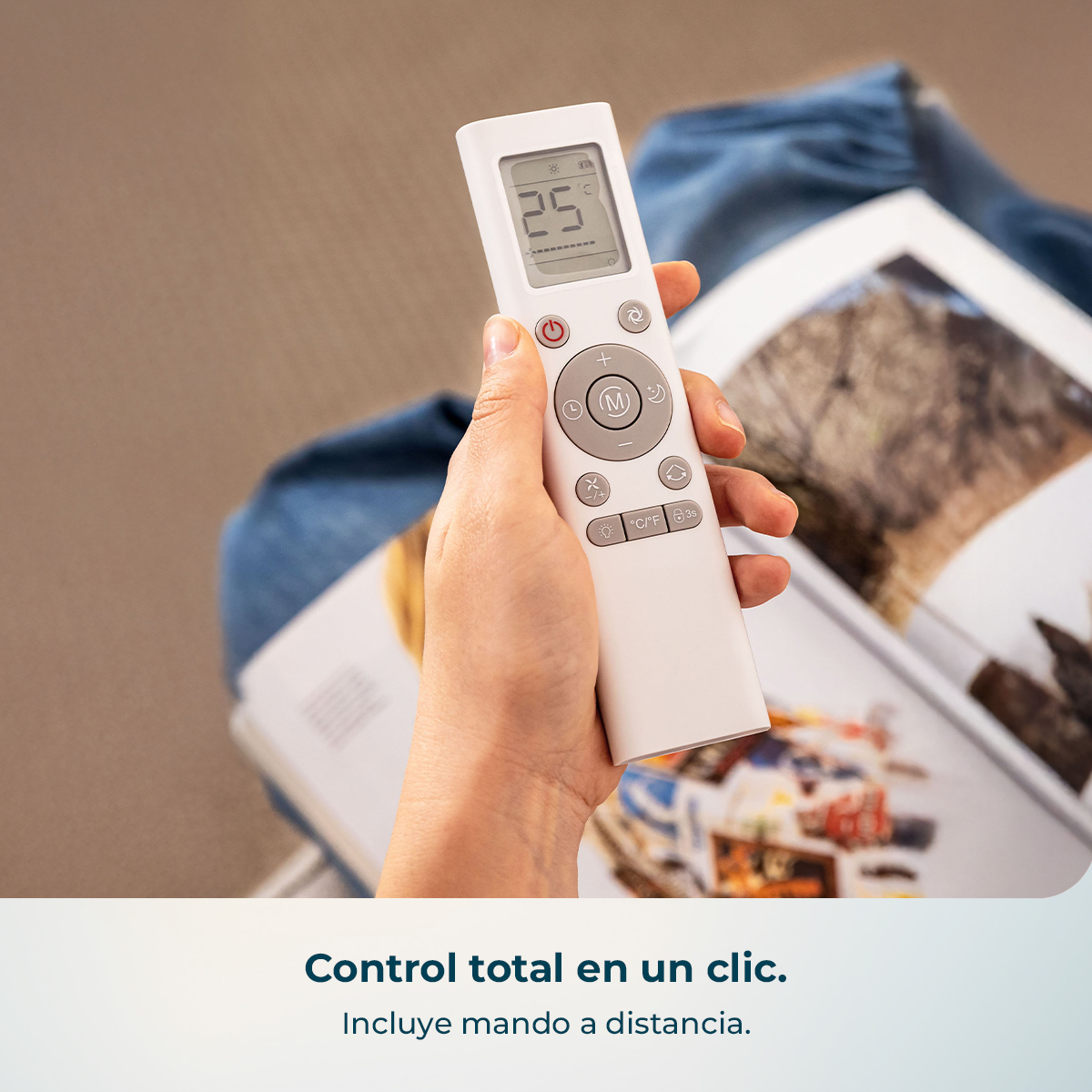 Una mano sostiene un mando a distancia blanco que muestra 25°C.