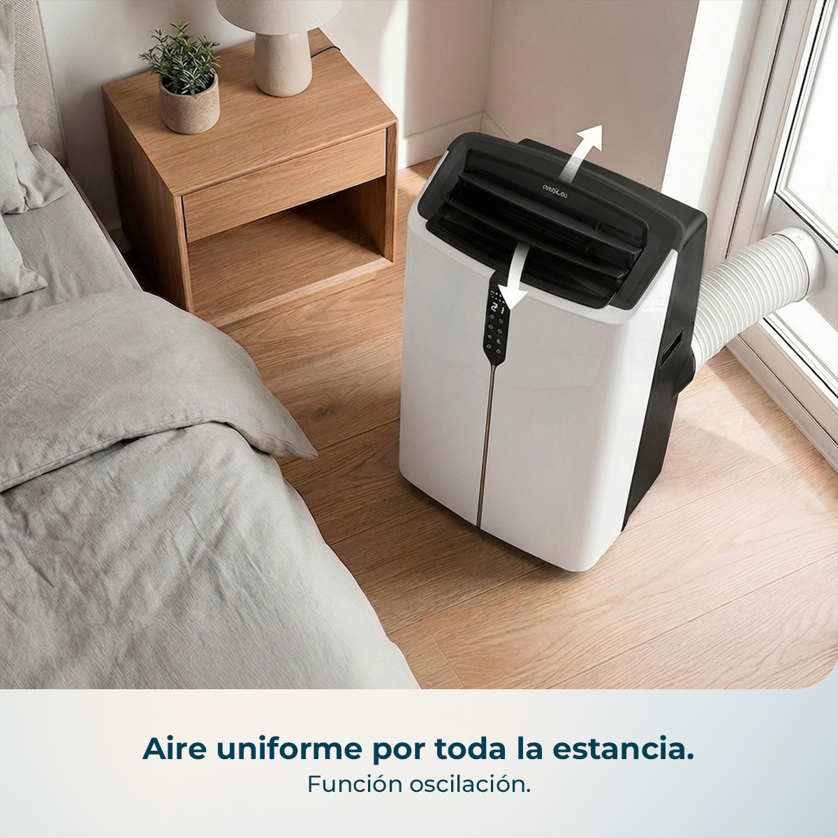 Un aire acondicionado portátil blanco y negro con manguera junto a una cama.