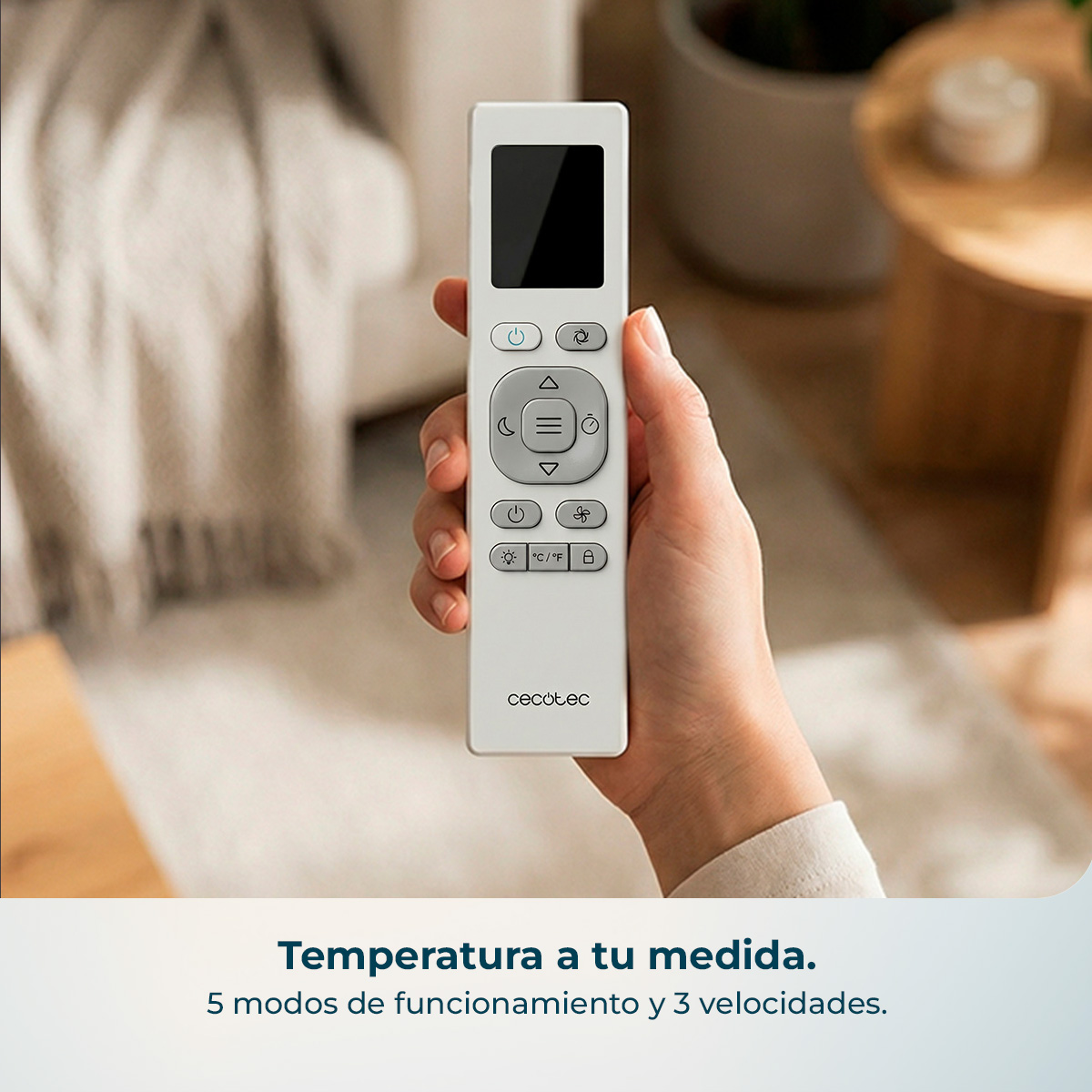 Una mano sostiene un mando a distancia blanco con pantalla negra y botones.
