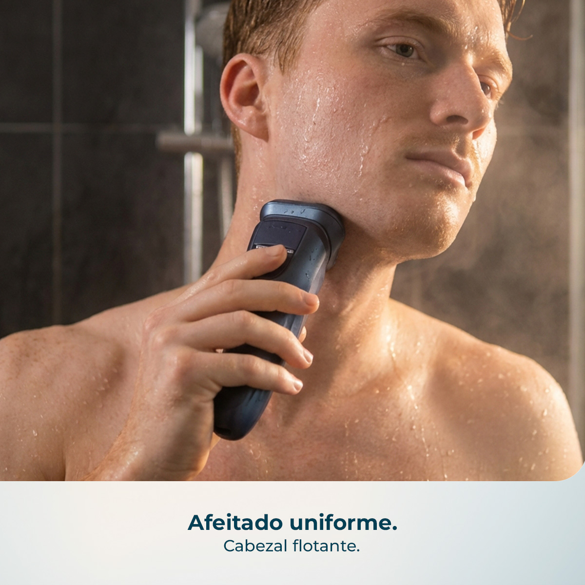 Hombre afeitándose en un baño húmedo con una afeitadora eléctrica.