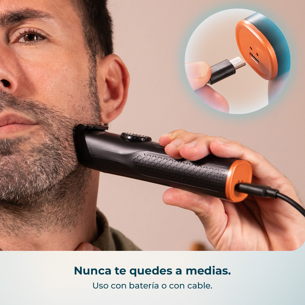 Hombre se afeita con recortadora negra y naranja que se está cargando.