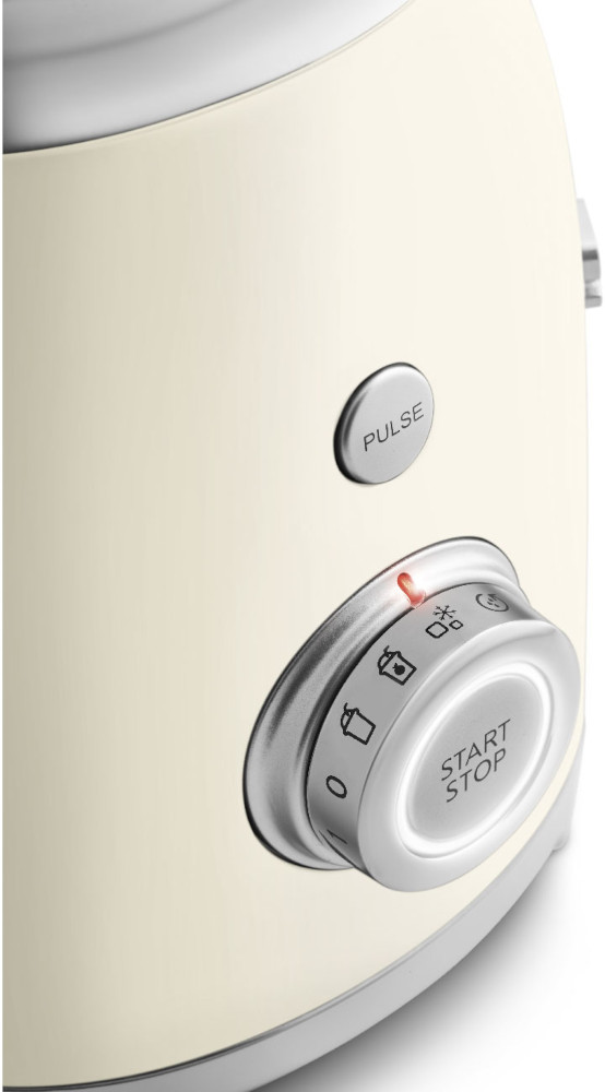 Close-up of a cream-colored blender with silver controls and a light.