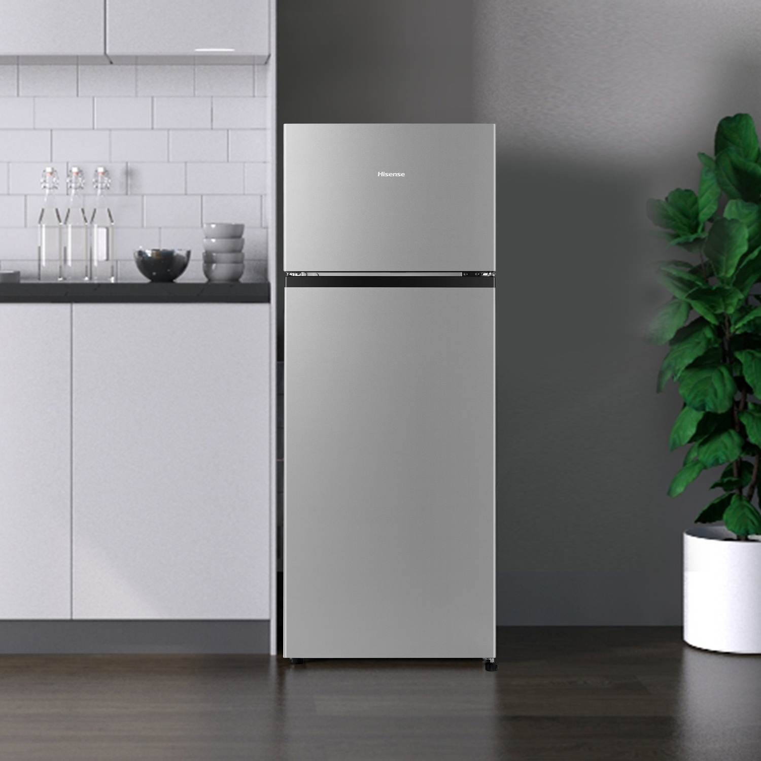 Un frigorifero Hisense argentato in una cucina moderna con paraschizzi piastrellato bianco e pianta.