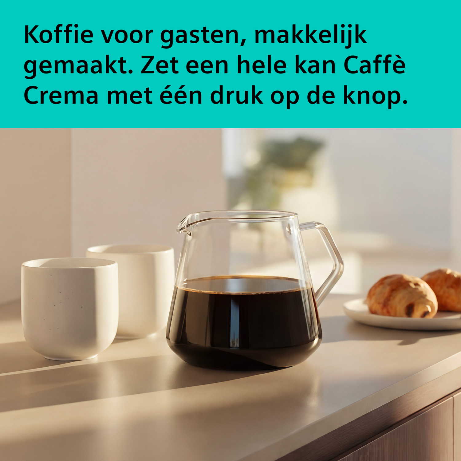 Een glazen karaf met koffie naast twee witte kopjes en croissants.