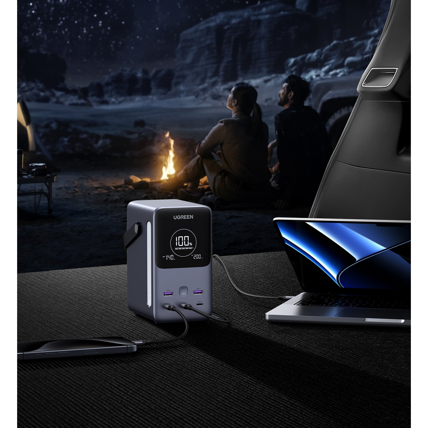 Scena di campeggio notturno: power bank carica laptop e telefono vicino al falò con cielo stellato.