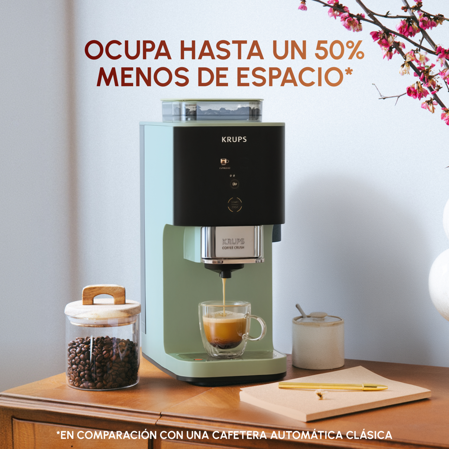 Una cafetera Krups verde menta prepara espresso en una taza de cristal.