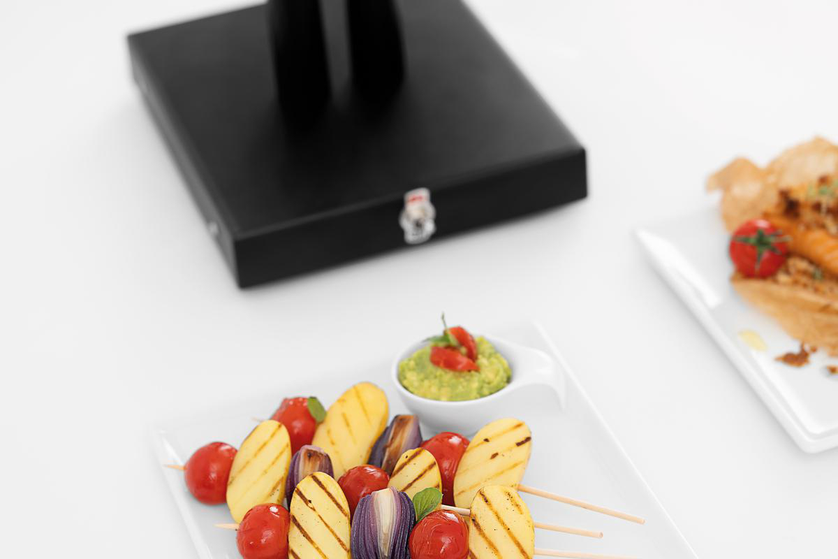 Gegrillte Spieße mit Kartoffeln, Tomaten und Zwiebeln, serviert mit Guacamole.