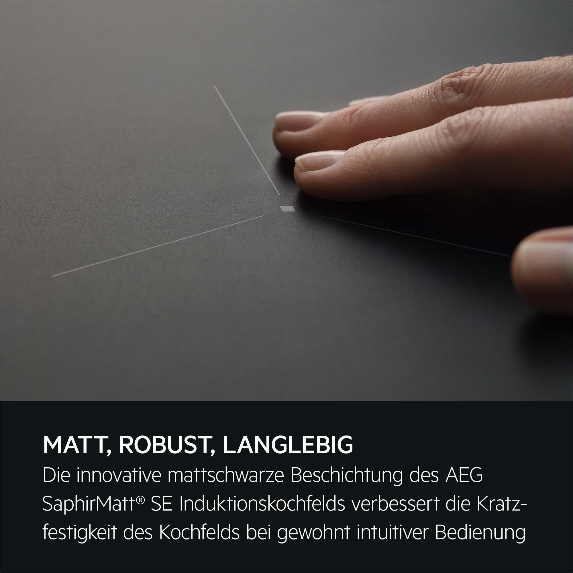 Eine Hand berührt ein mattschwarzes Kochfeld mit feinen Linien.