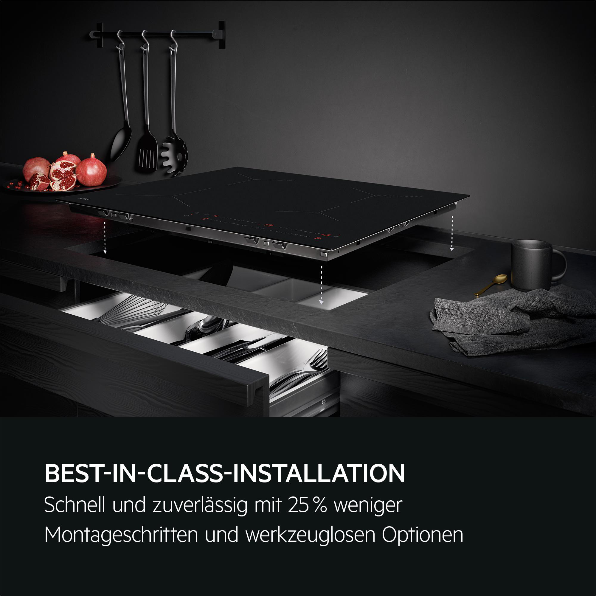 Ein Induktionskochfeld wird in eine Arbeitsplatte eingebaut. Obst und Küchenutensilien sind zu sehen.