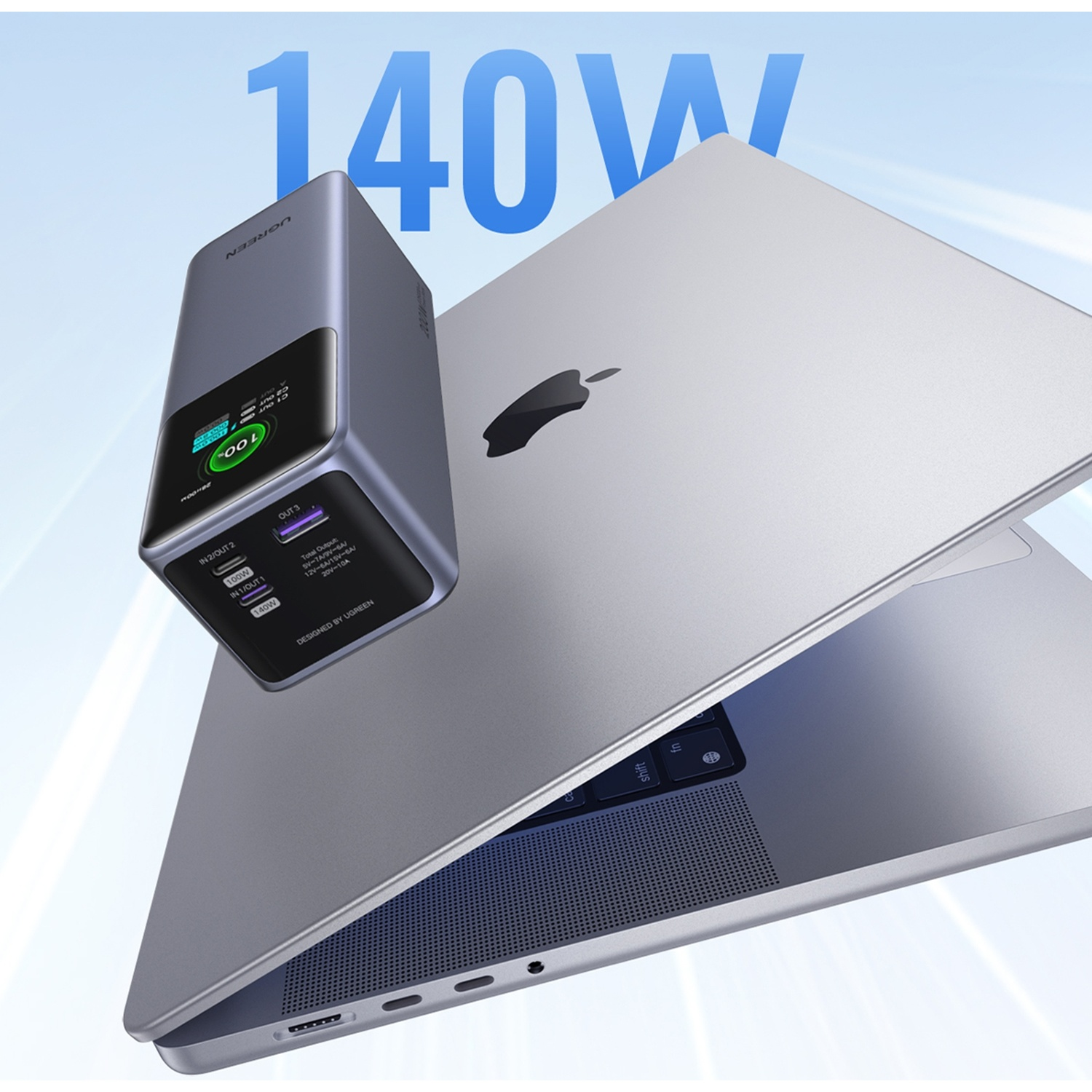 Un power bank UGREEN grigio con carica al 100% appoggiato su un MacBook Pro argento, con la scritta "140W" sullo sfondo.