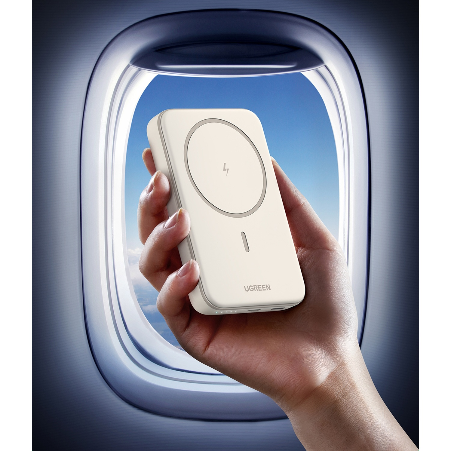 Una mano tiene un caricatore bianco davanti all'oblò di un aereo.