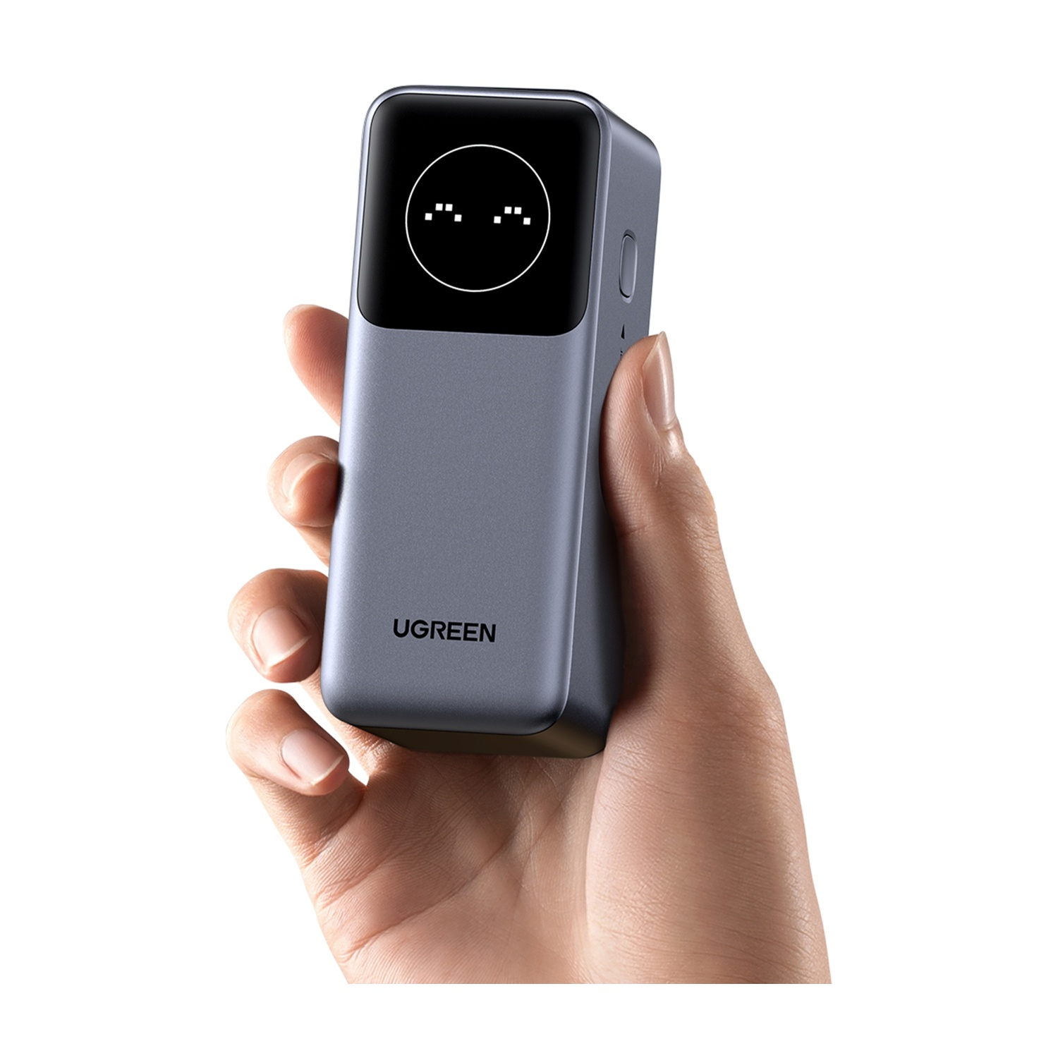 Una mano tiene un dispositivo UGREEN grigio con una faccia digitale sullo schermo.