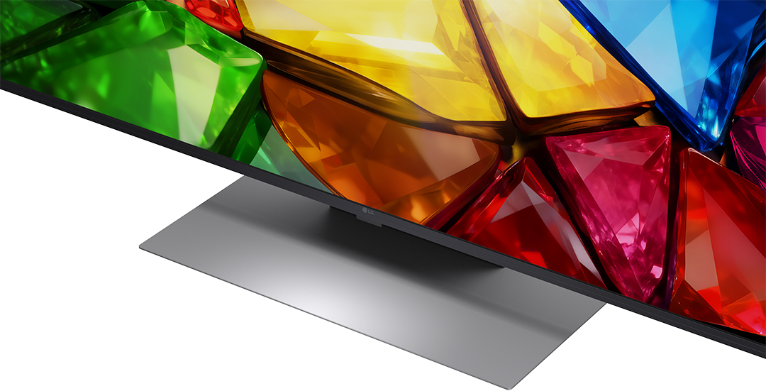 Egy modern LG TV színes, facettált képernyőháttérrel és ezüst állvánnyal.