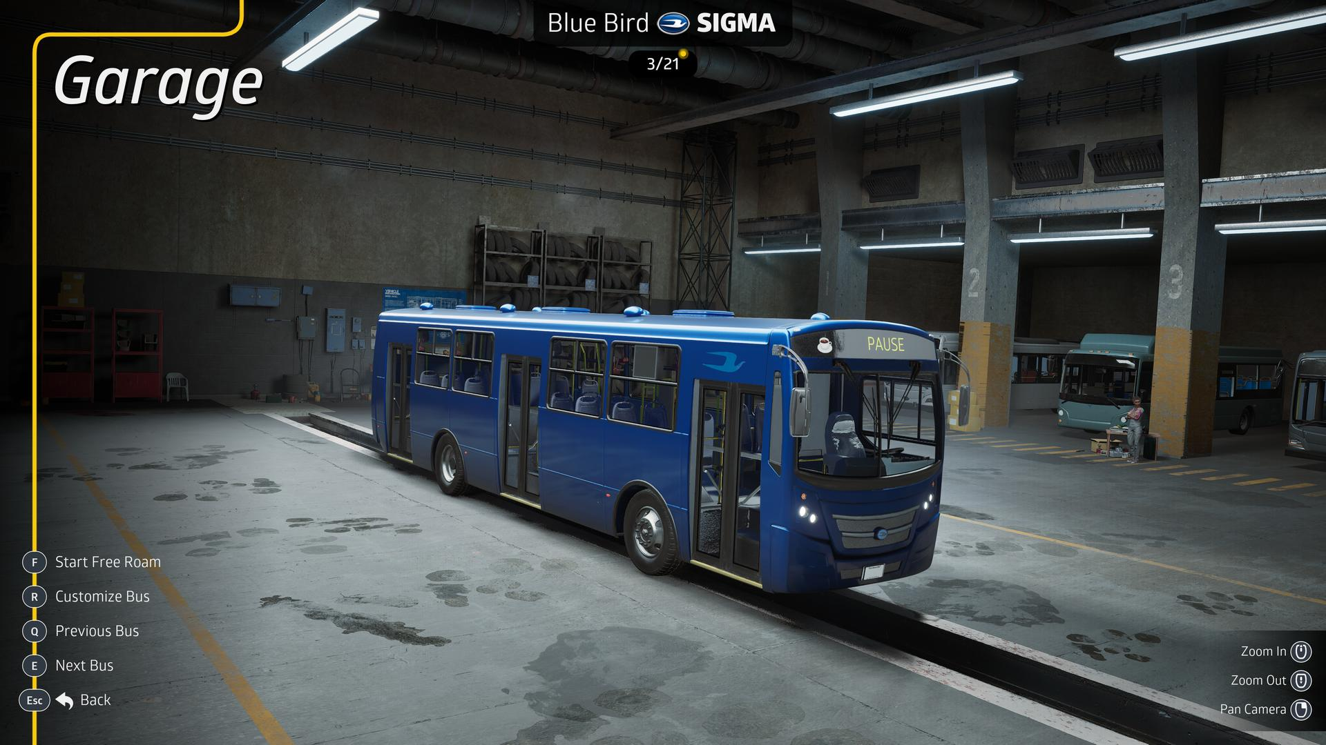 Ein blauer Bus steht in einer Werkstatt neben anderen Bussen. Die Werkstatt hat Betonwände.