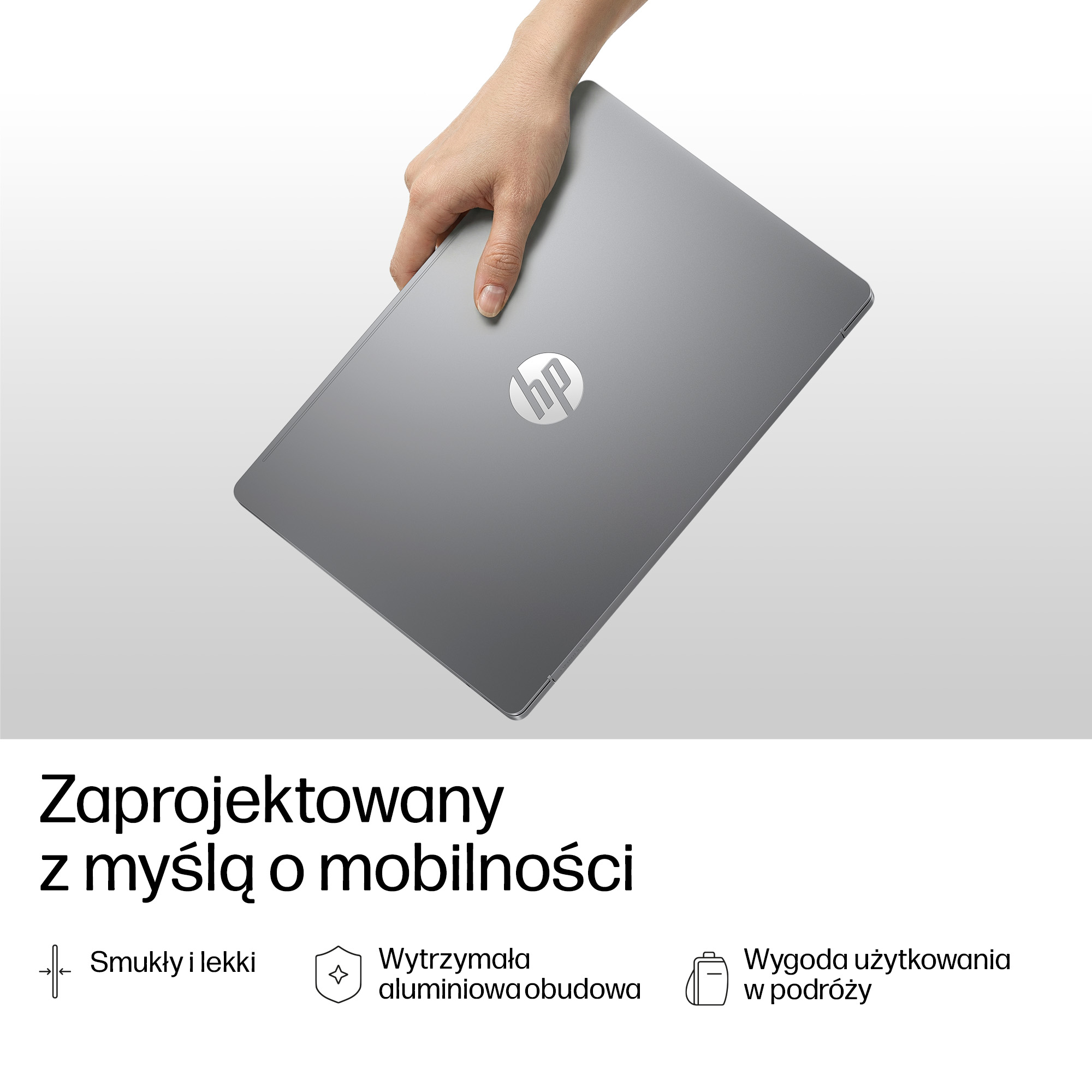 Dłoń trzyma zamkniętego, szarego laptopa HP z logo HP.