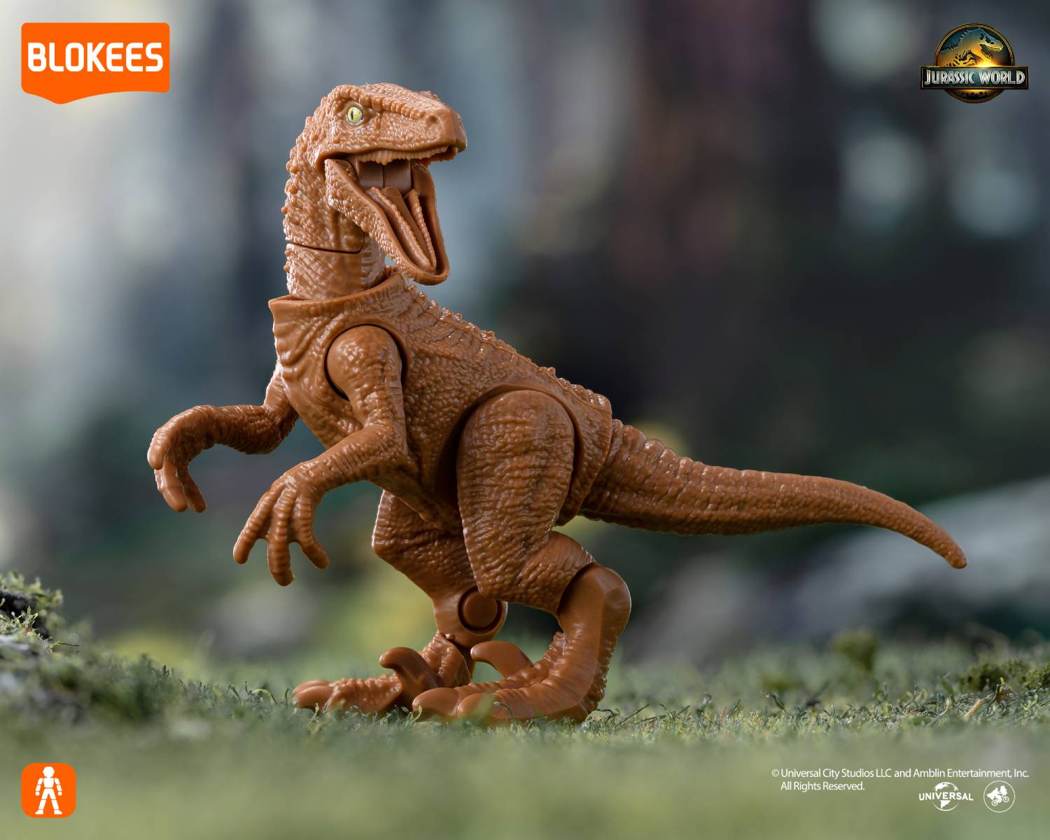 Figura de dinosaurio marrón sobre hierba, con logos BLOKEES y JURASSIC WORLD.