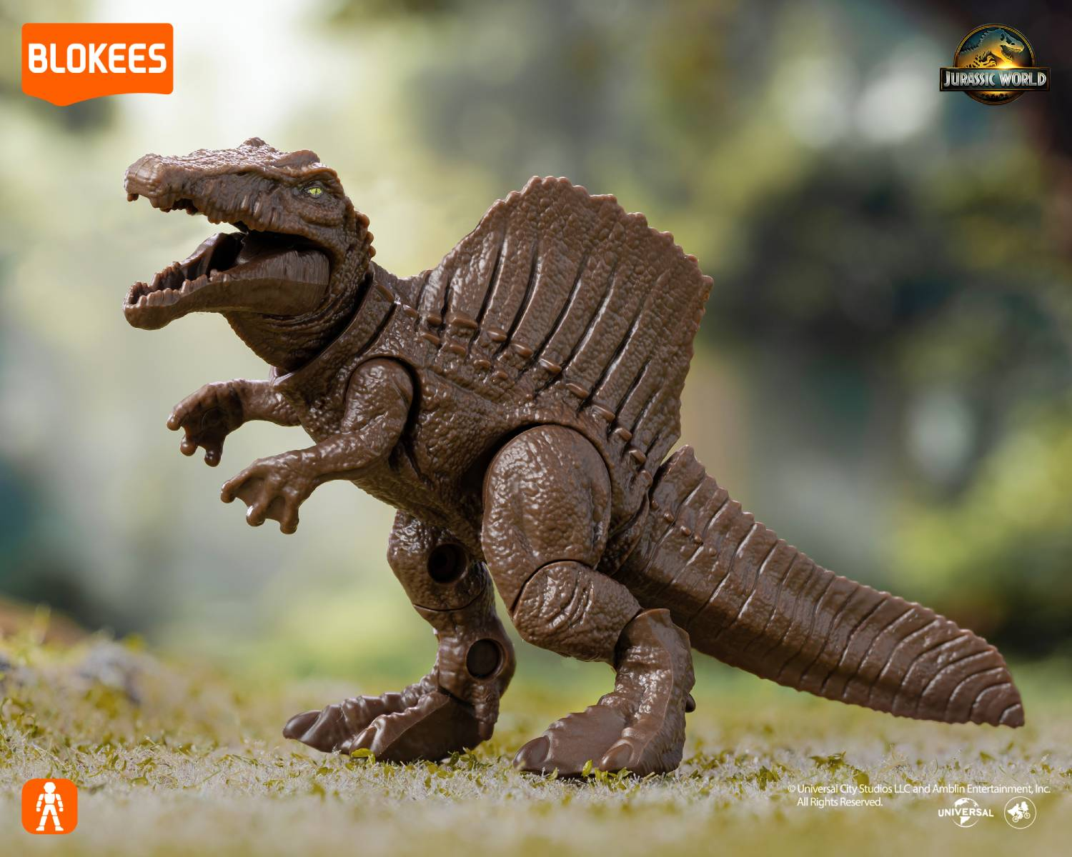 Juguete marrón de Spinosaurus con boca abierta sobre hierba.