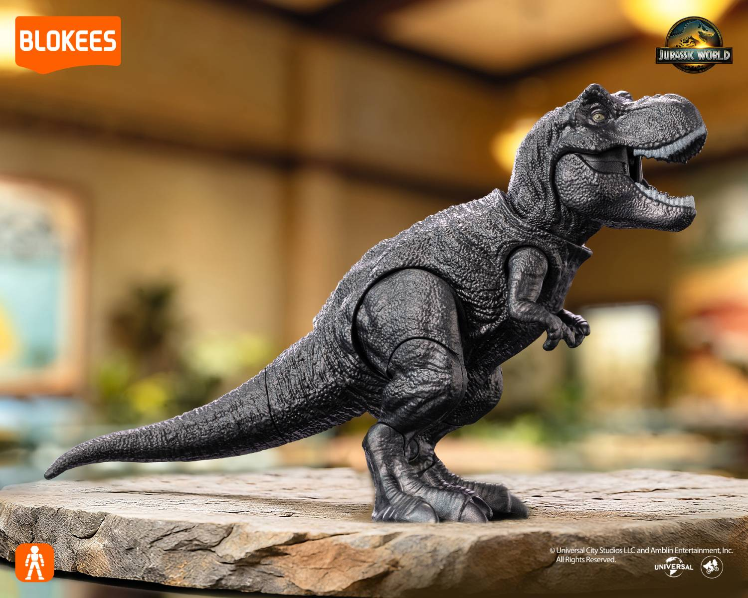 Un juguete de Tyrannosaurus Rex negro se alza sobre una roca. Logo de Jurassic World.
