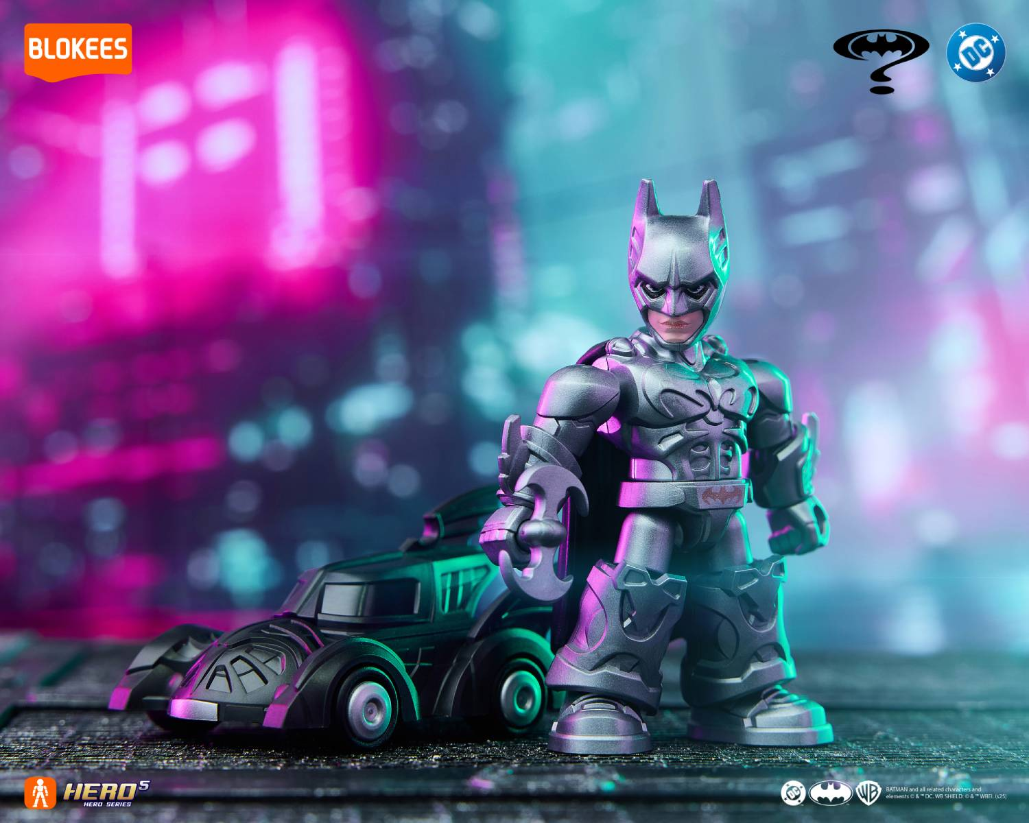 Figura de Batman con su vehículo frente a un fondo urbano borroso y con luces de neón.